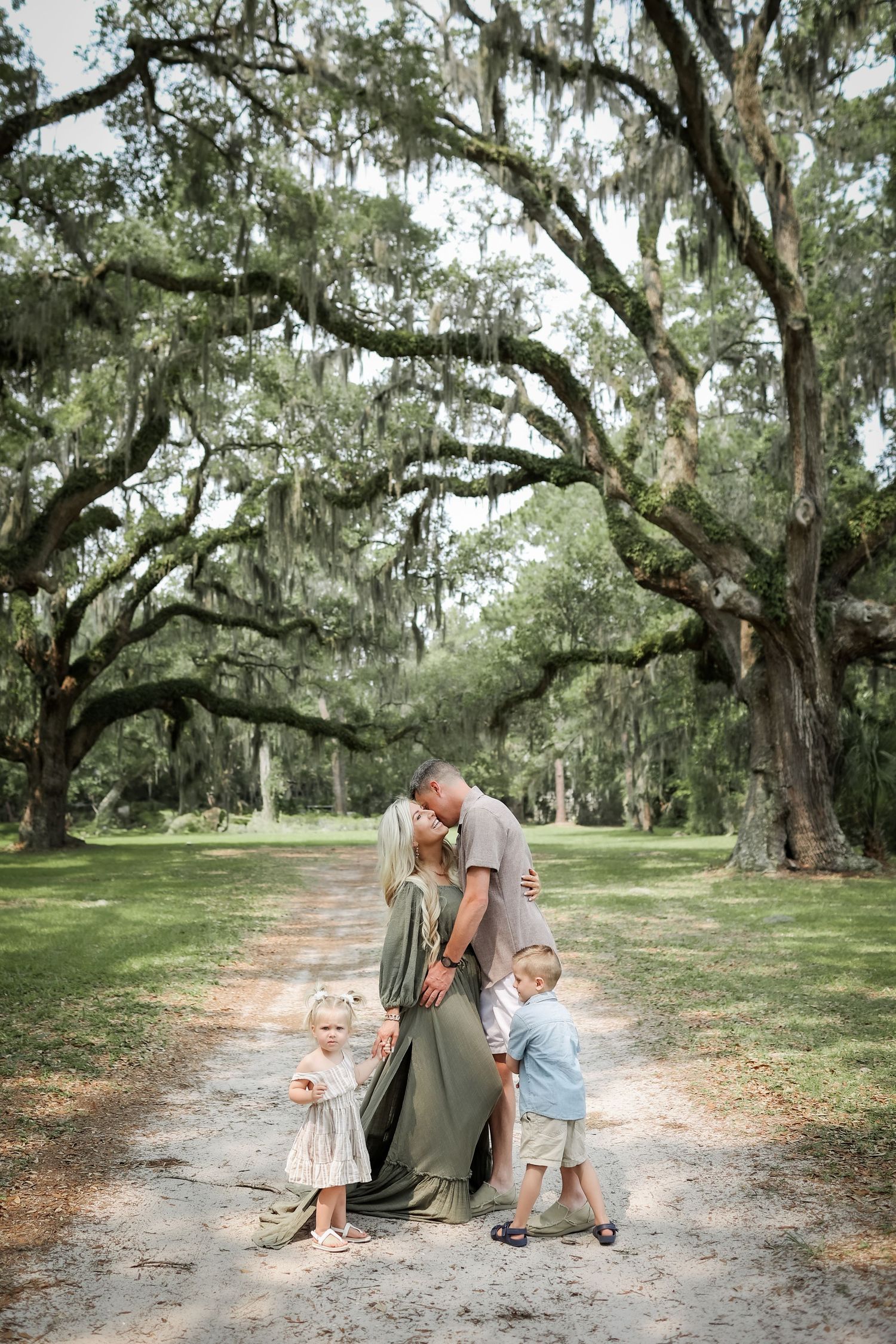 Hilton Head family photography with young family hugging under live oak trees in Sea Pines on Hilton Head Island