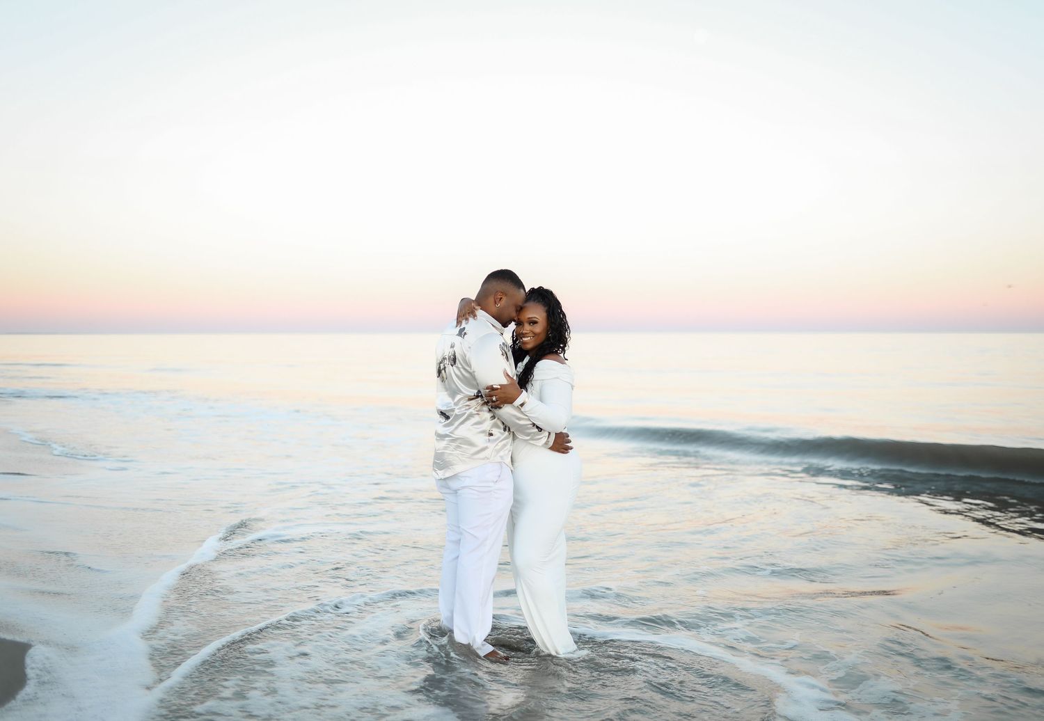 Hilton Head couples photography featuring a Black couple standing in the water at sunset on Folly Field Beach