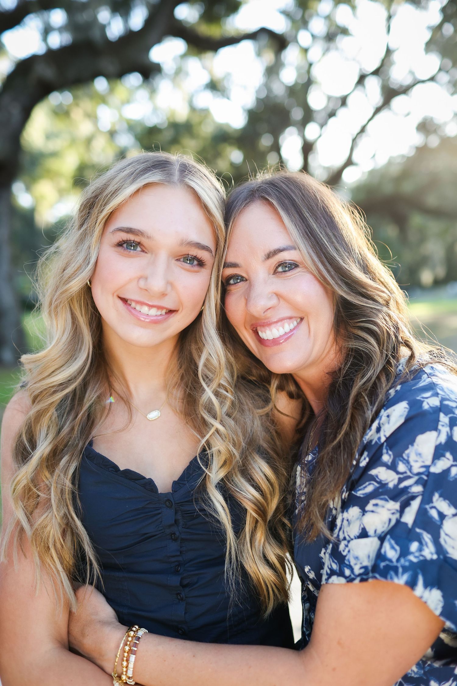Hilton Head family photography showing a mother and teenage daughter hugging among Lowcountry oak trees in Sea Pines