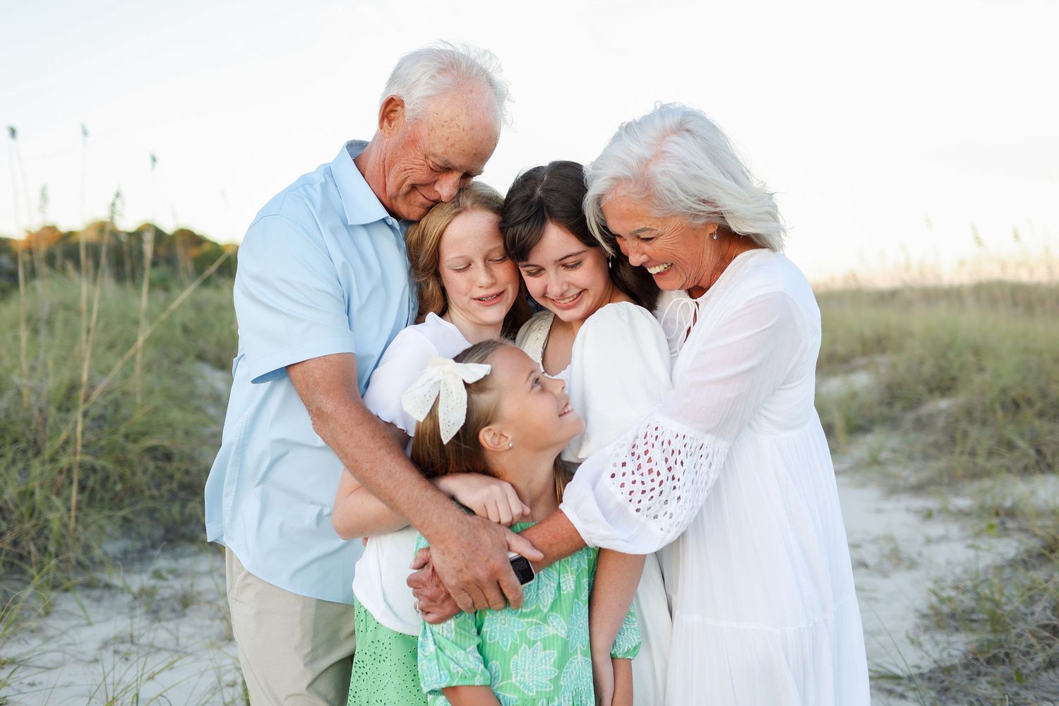 Grandparents and grandkids hugging during family reunion photos at Folly Field Beach on Hilton Head Island