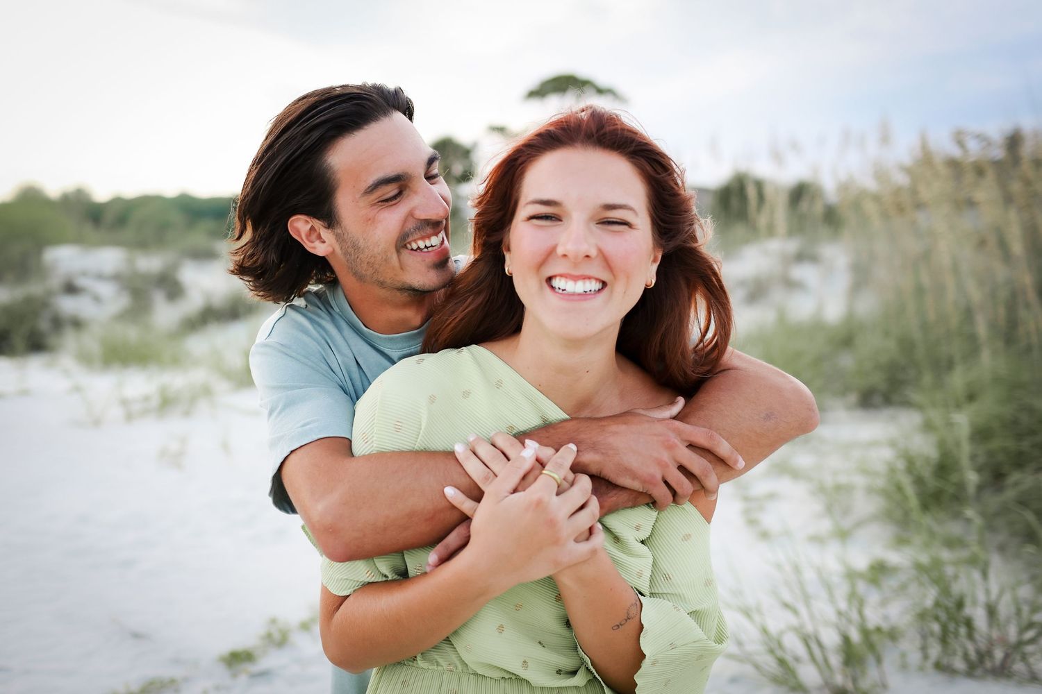 Couples photography on Hilton Head Island, man hugging woman from behind during relaxed beach session