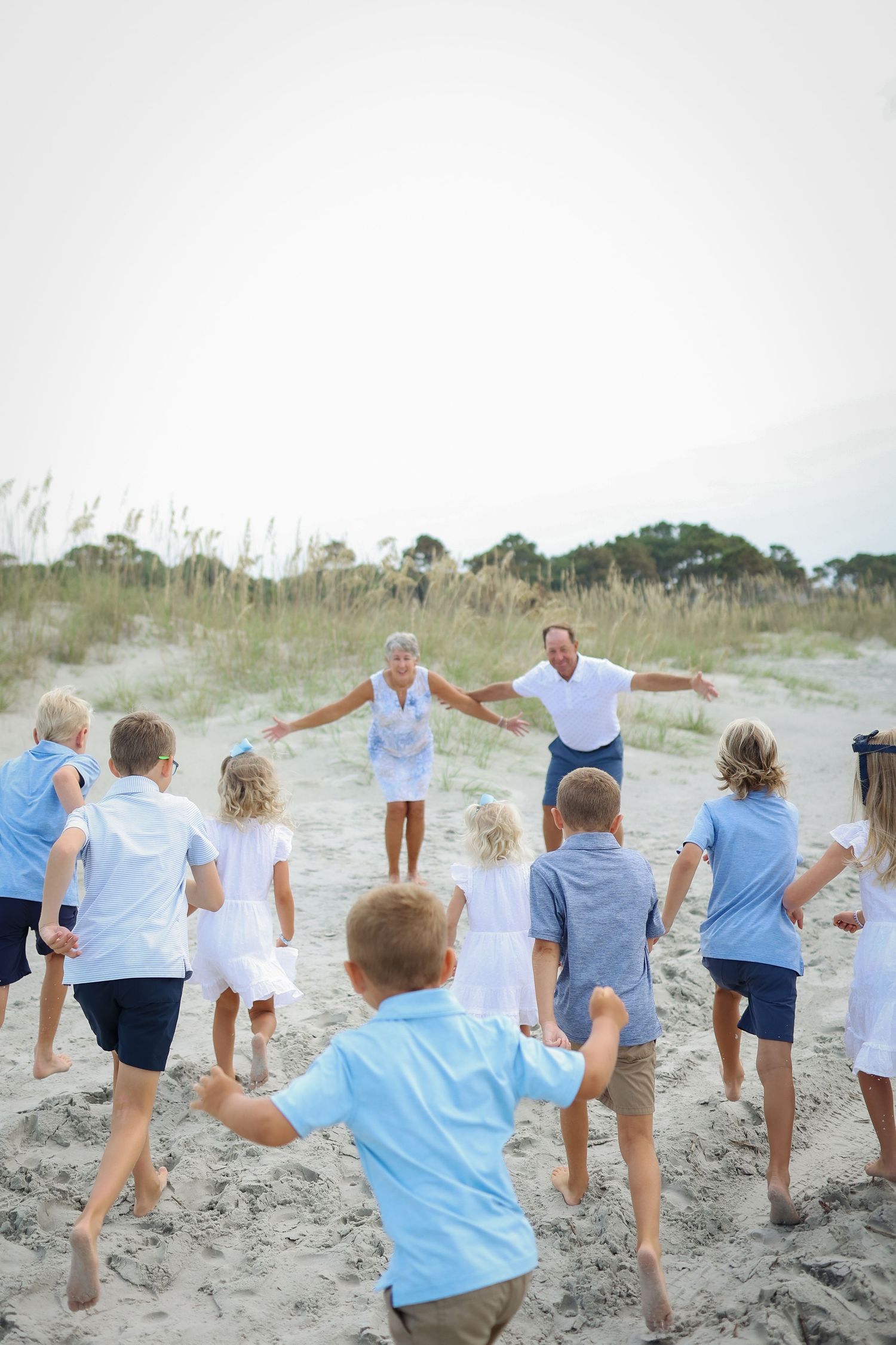 Family reunion photography on Hilton Head Island with grandkids running to grandparents in sand dunes near Coligny Beach