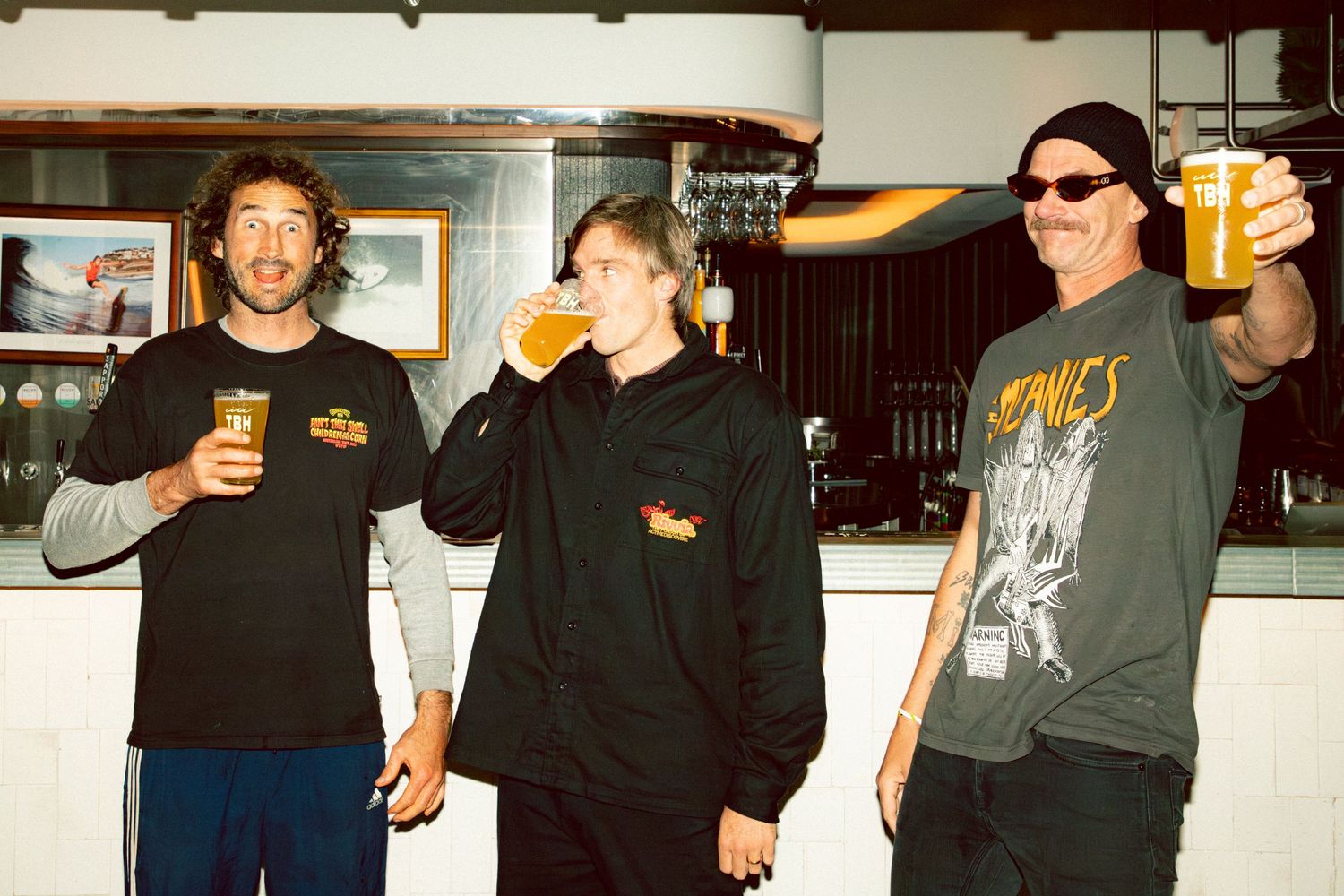 Ryan Callinan with Aint That Swell podcast boys smiling and raising beer glasses at The Beach Hotel Merewether.
