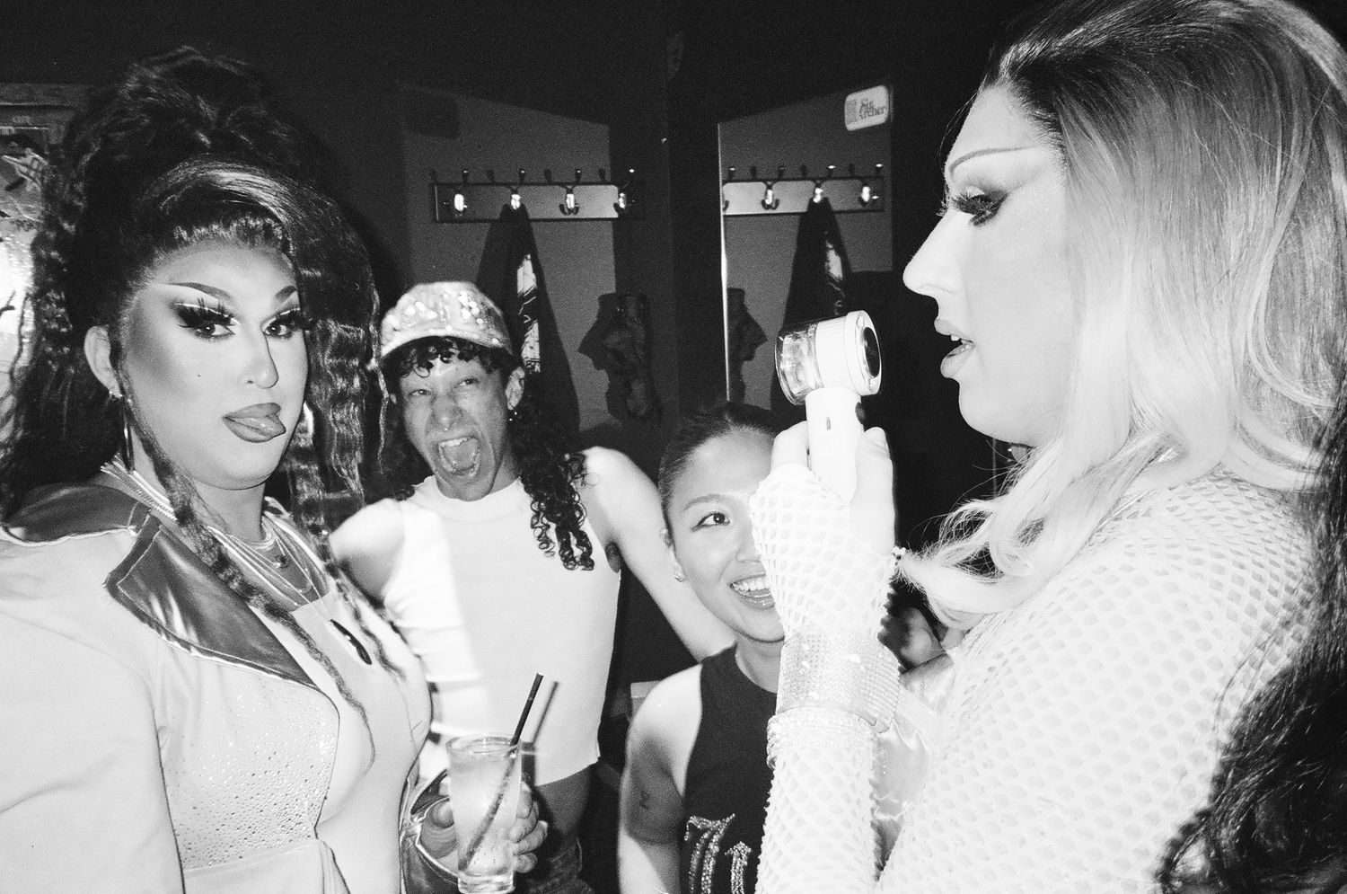 Two drag queens facing each other in conversation at a lively nightclub event at The Station Hotel for Poof Doof.