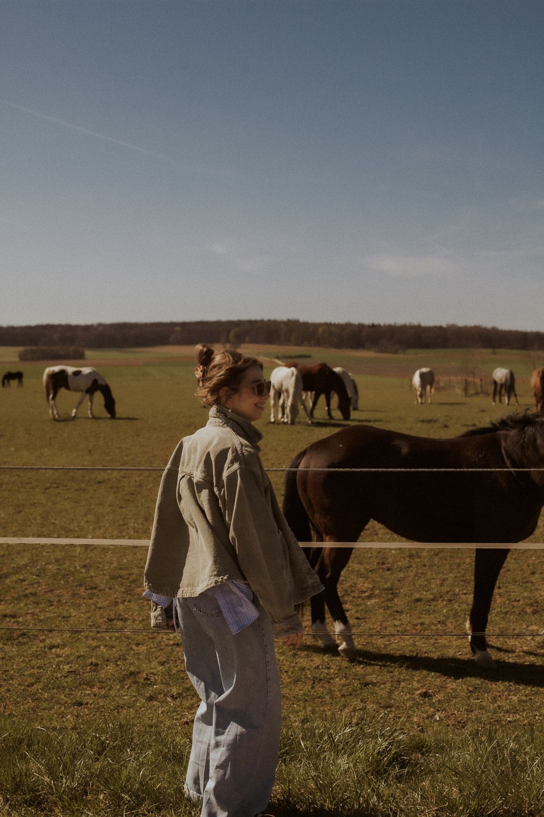 Denise Haberl steht vor Pferden auf der Weide – Storytelling Fotoshooting Ingolstadt