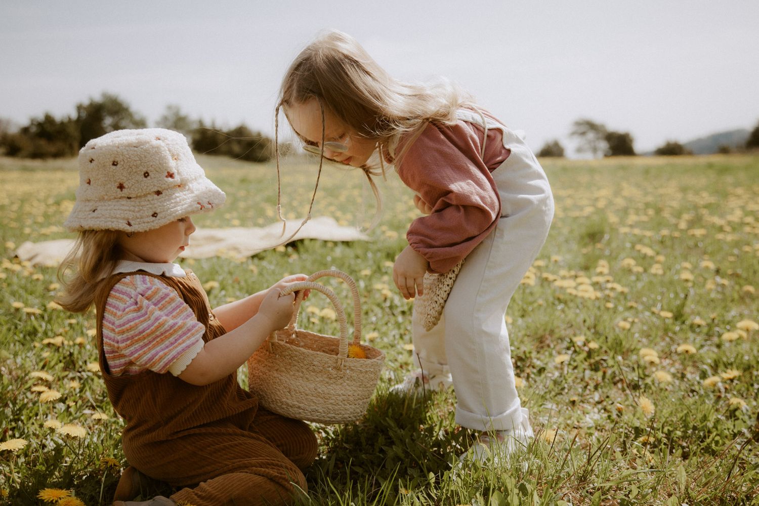 Zwei Mädchen spielen gemeinsam auf einer Sommerwiese – Kinderfotografie Ingolstadt