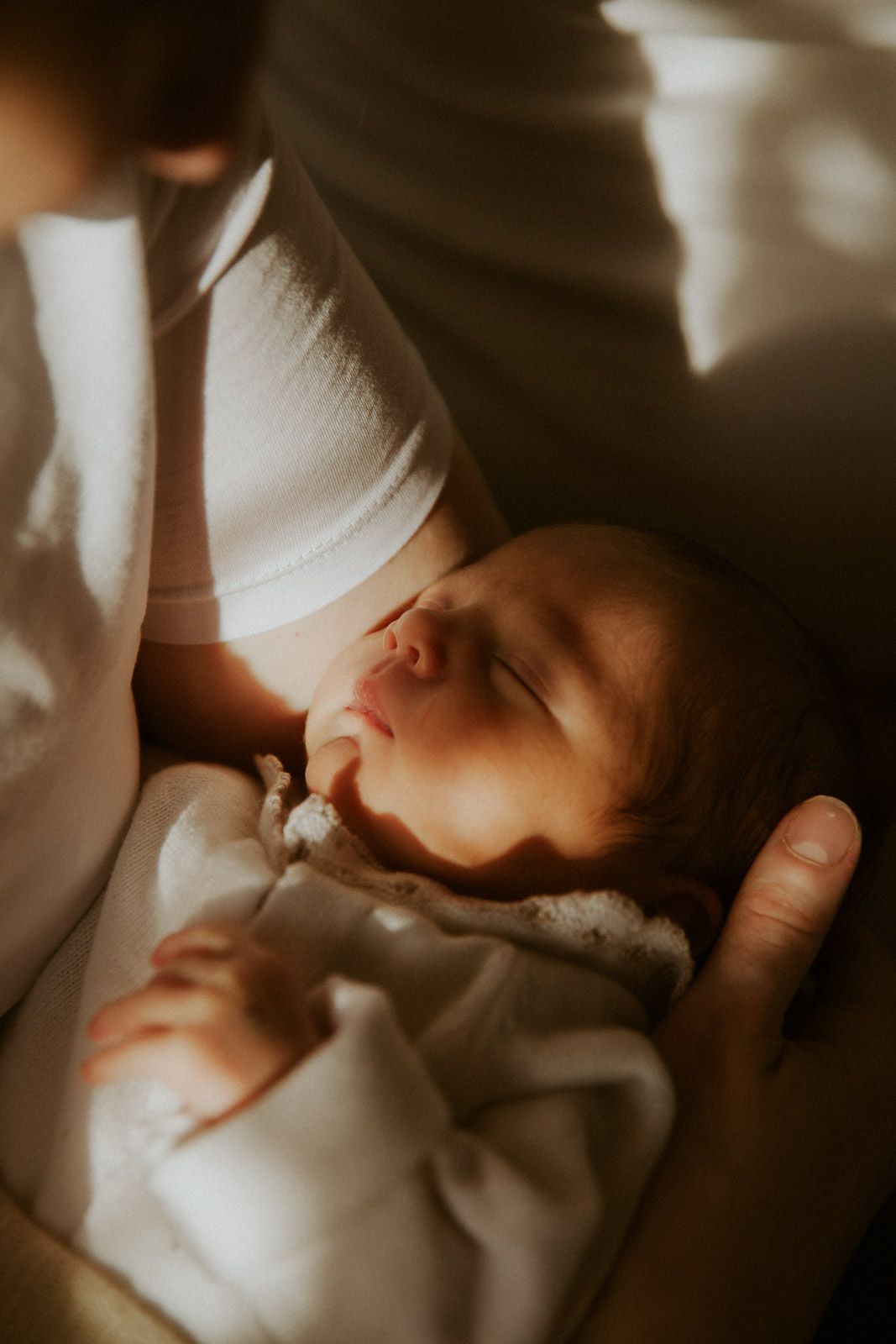 Mutter stillt glücklich nach der Geburt im Sonnenlicht