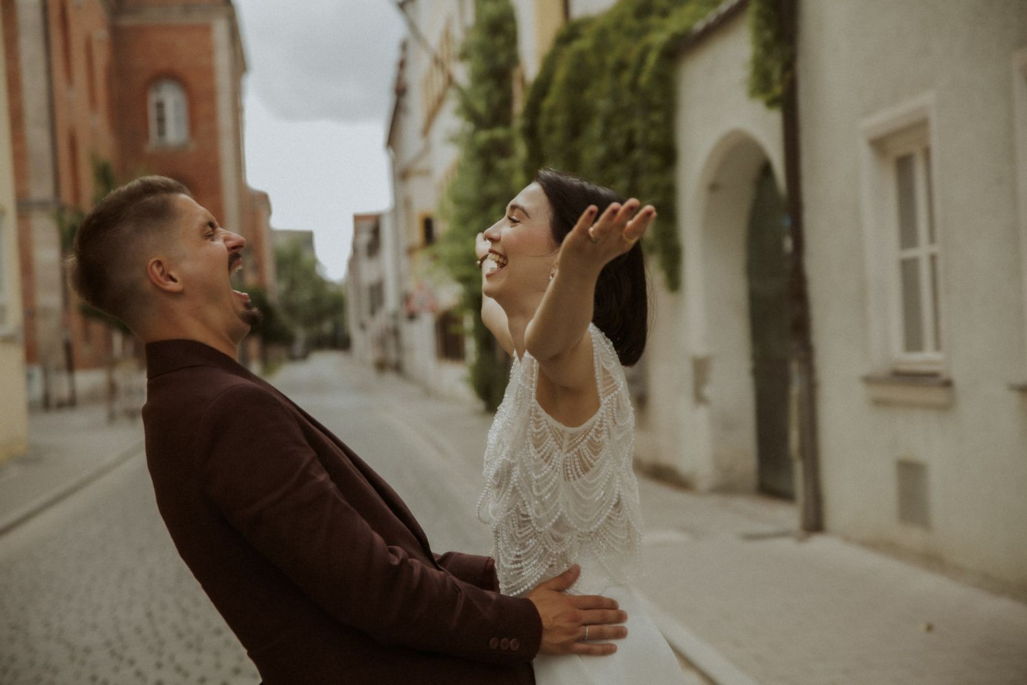 Brautpaar lacht ausgelassen in einer malerischen Altstadtgasse – Hochzeitsfotografin Ingolstadt