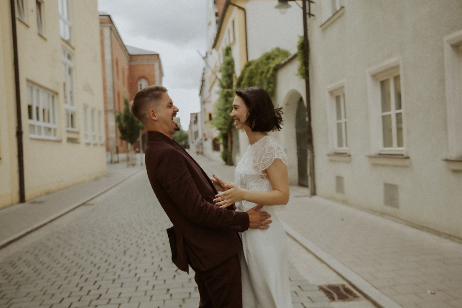 Brautpaar lacht gemeinsam in einer romantischen Altstadtgasse Ingolstadt