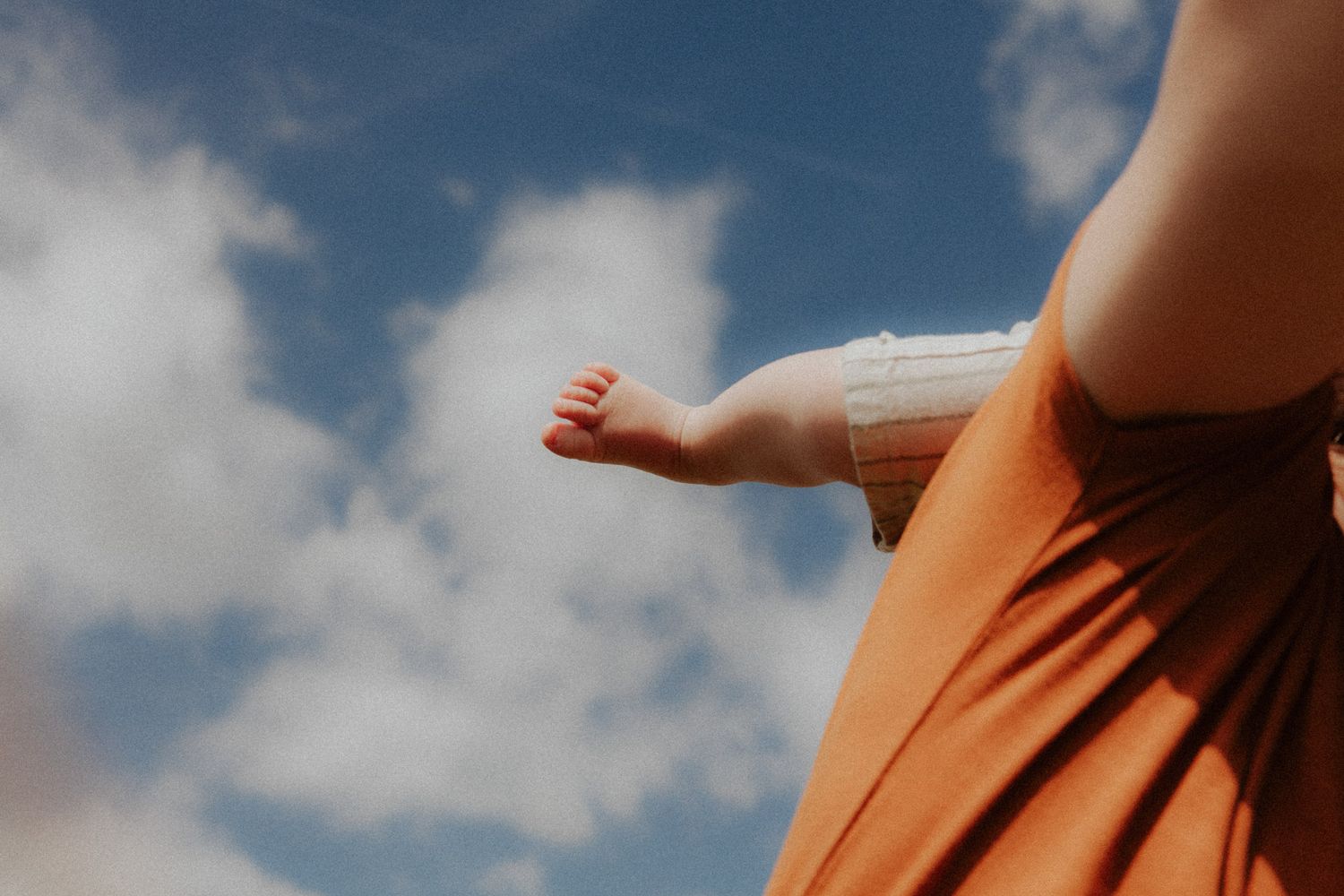 Kleinkind streckt die Beine in den blauen Himmel – Detailaufnahme