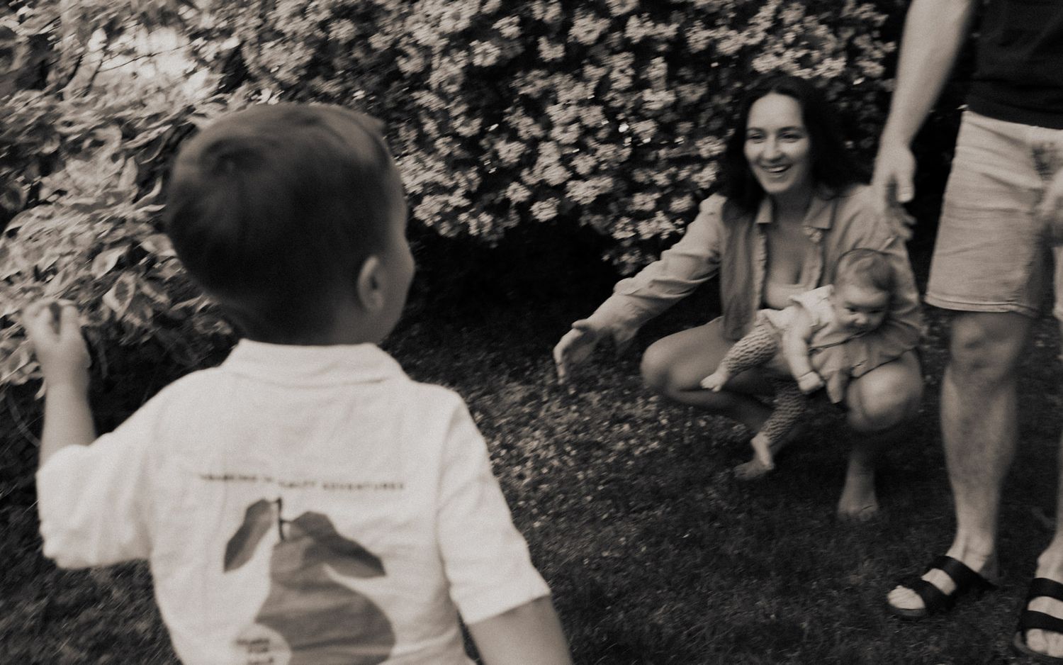 Mutter lacht mit Neugeborenem im Arm während Kleinkind zuläuft – Familienfotografin Ingolstadt