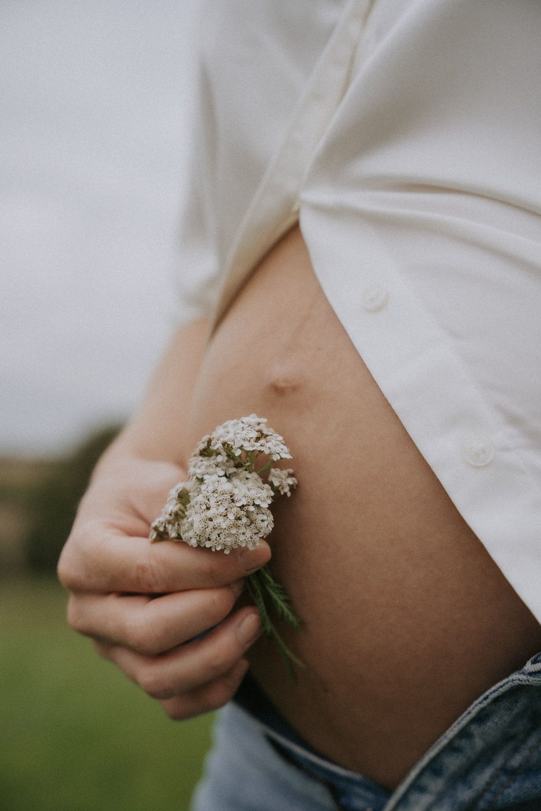 Werdende Mutter hält Babybauch mit Wildblumen – Babybauchfotografie Ingolstadt