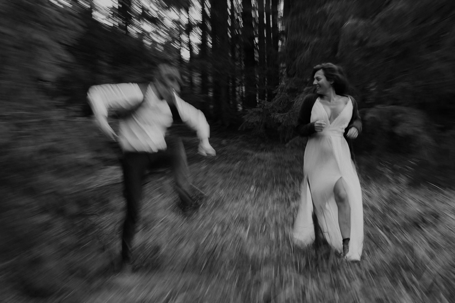 Verwacklte Schwarz-Weiß Aufnahme tanzendes Brautpaar im Wald – kreative Hochzeitsfotografie