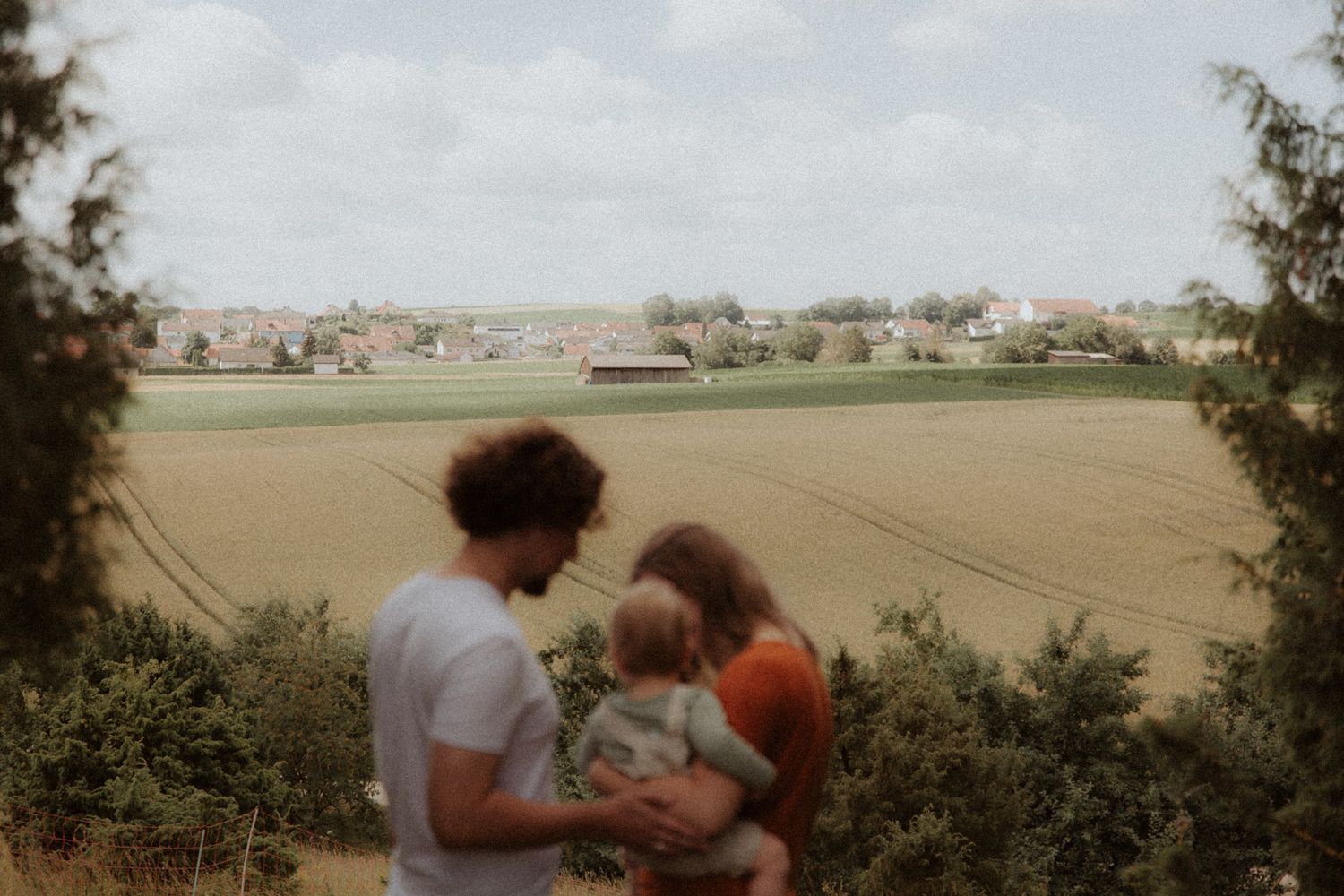 Familie spaziert auf einem Hügel mit Blick über die bayerische Landschaft
