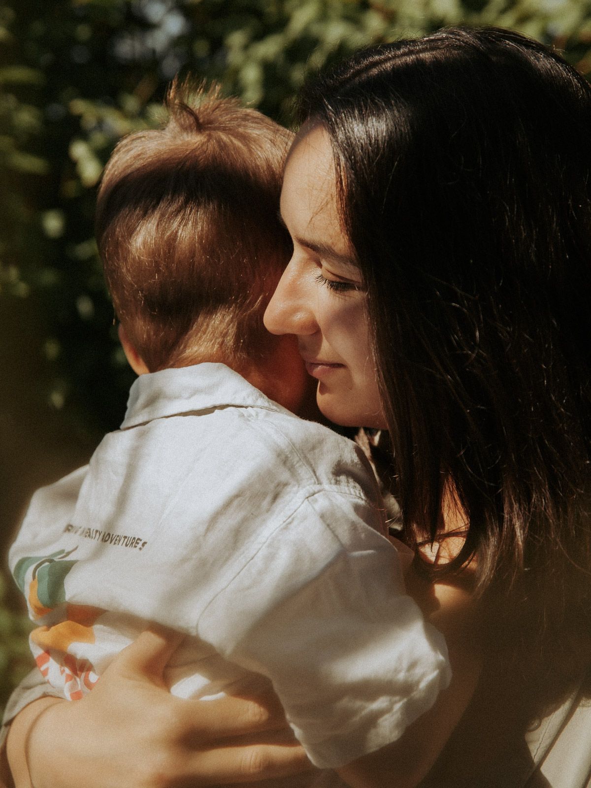 Mutter umarmt ihr Kind zärtlich im Sonnenlicht – emotionale Familienfotografie Ingolstadt