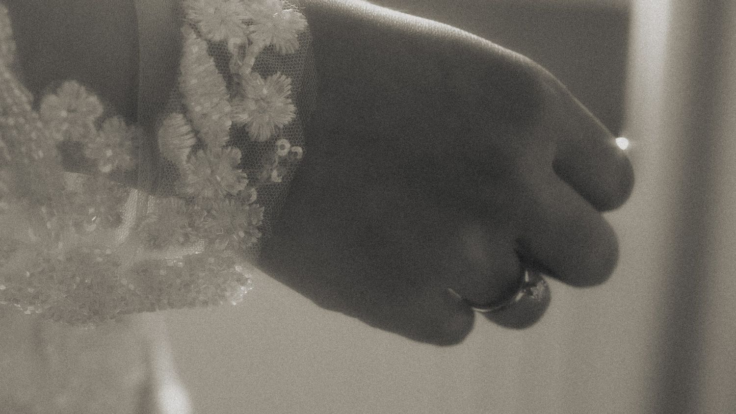 Schwarz-Weiß Detailaufnahme Brautkleid mit Spitze und Ehering – Hochzeitsfotografie