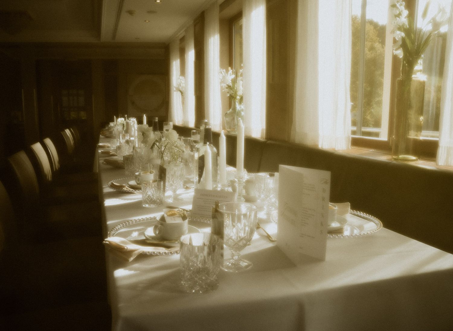 Festlich gedeckter Hochzeitstisch im Kerzenlicht eines historischen Saals