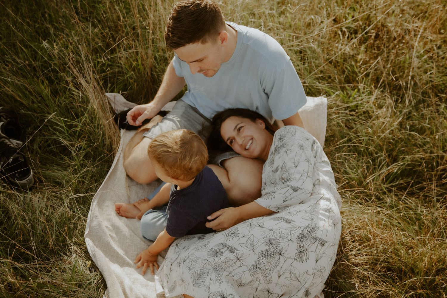 Familie kuschelt lachend zusammen im hohen Gras – Familienfotografin Ingolstadt