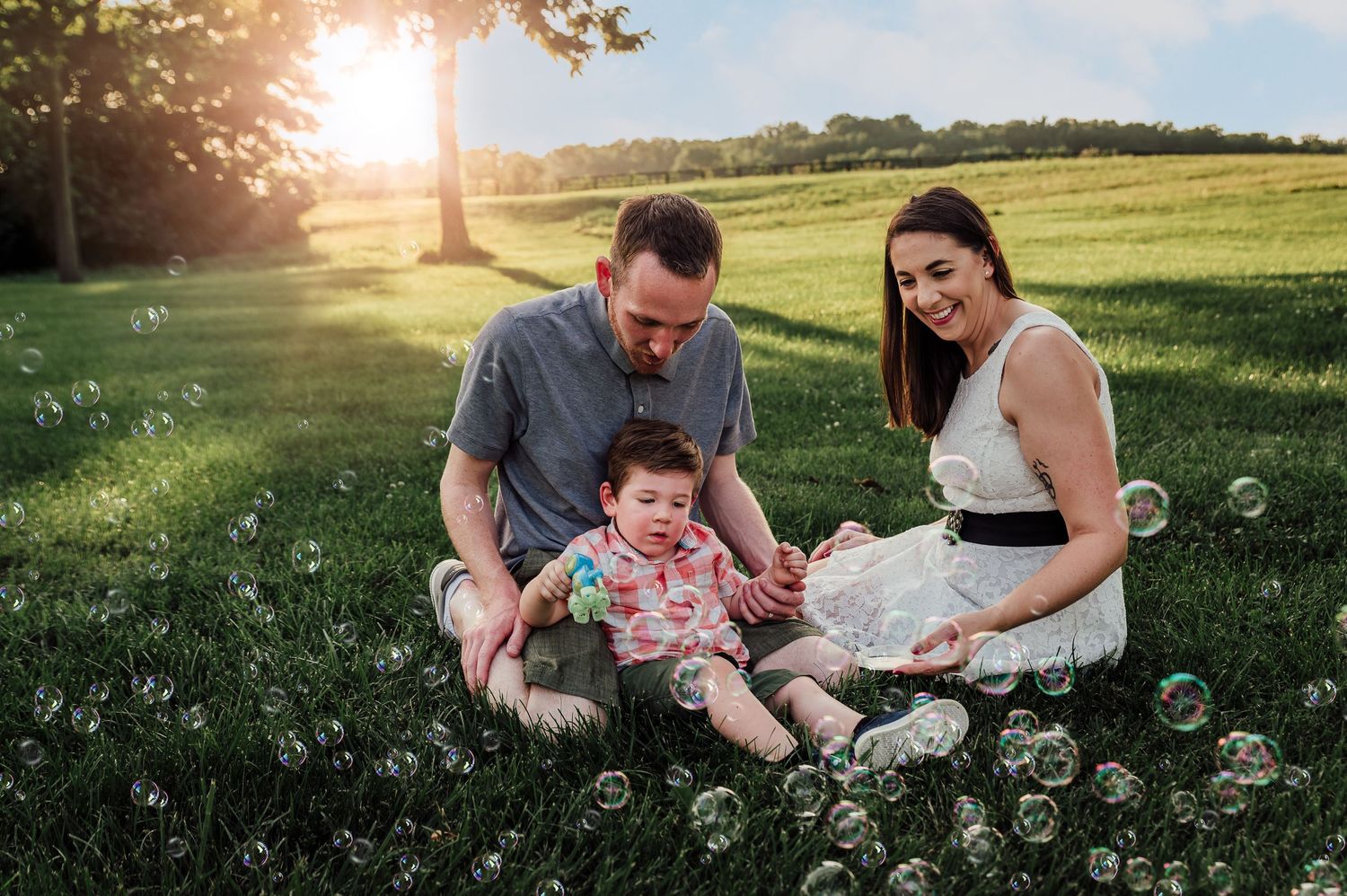 Family maternity photoshoot in Berryville Virginia with a little boy playing with bubbles