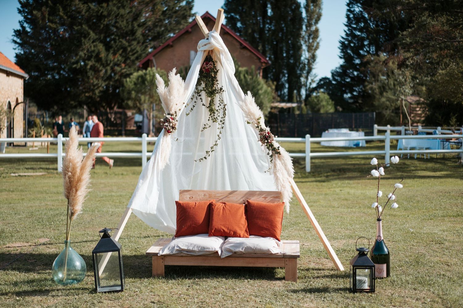 Décoration bohème pour un mariage au Domaine Saint Laud à Angers – Arche en bois et coussins pour séance photo couple.