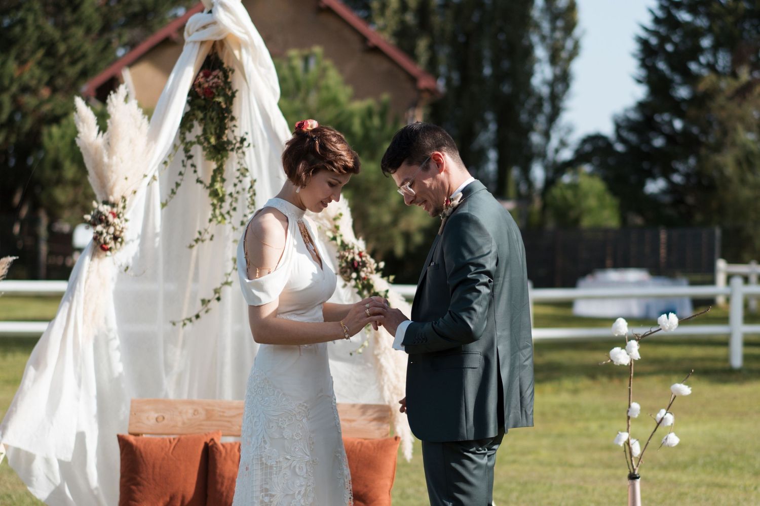 Le marié passe l'anneau au doigt de la mariée lors d'une cérémonie de mariage intime en plein air.