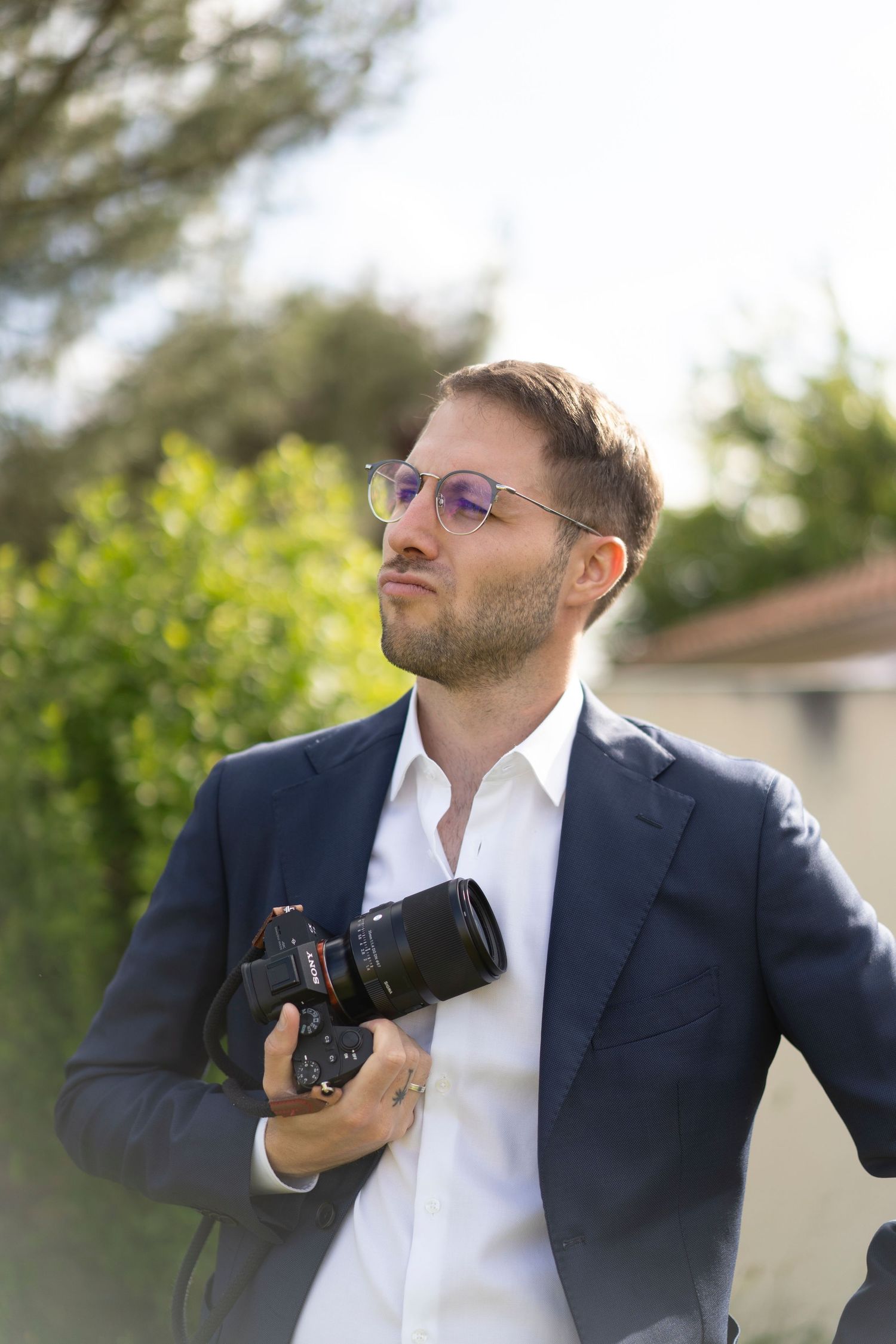 Portrait du photographe Keny – regard tourné vers la lumière, appareil photo à la main