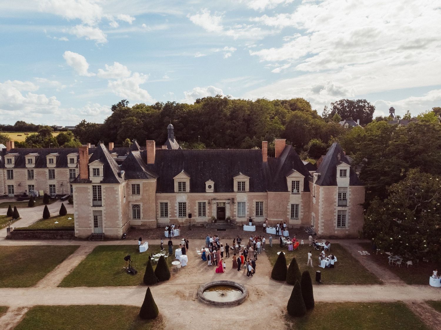 Vue aérienne du mariage au Château de la Perrière à Avrillé – Jardin à la française et façade majestueuse avec invités rassemblés.