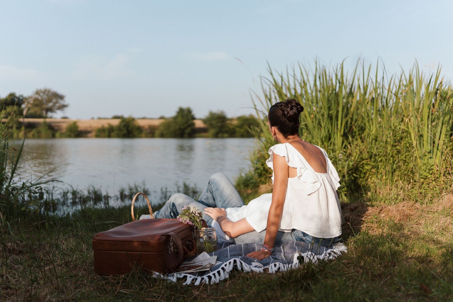 Pause détendue d’une future mariée au bord d’un étang, en pleine nature