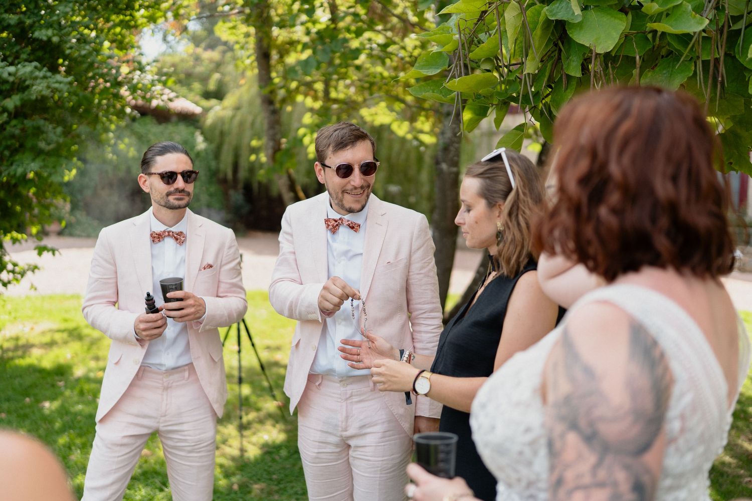 Invités en costume rose lors d’un mariage en extérieur – Moment convivial avec échanges et rires autour des mariés.