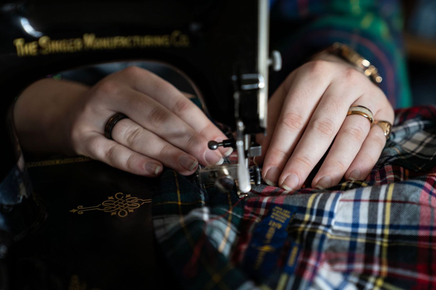 Detailed hand photo of someone sewing fabric. An editorial queer branding shoot. The company is an Arizona-based queer fashion brand.