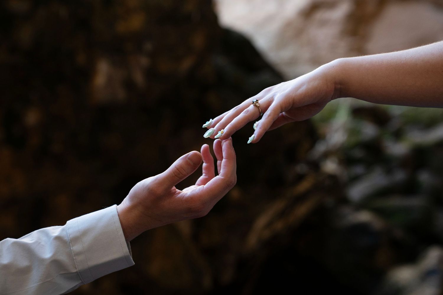 An engaged couple's hands reach out to each other, recreating 