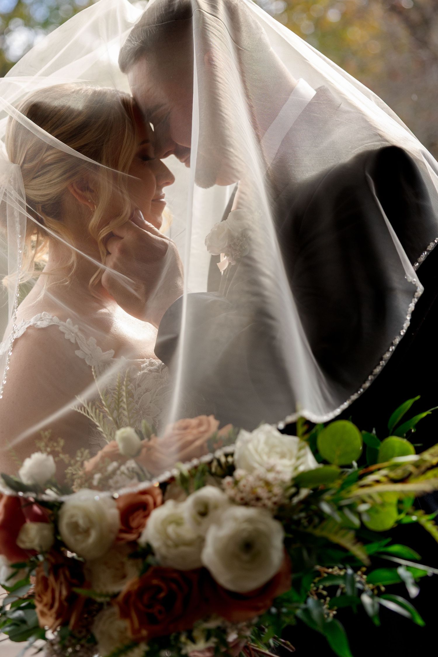 Bride and groom kissing under a veil at Saphire Estate in Sharon, Massachusetts, captured by Grand Photo by Karyna Oliinyk
