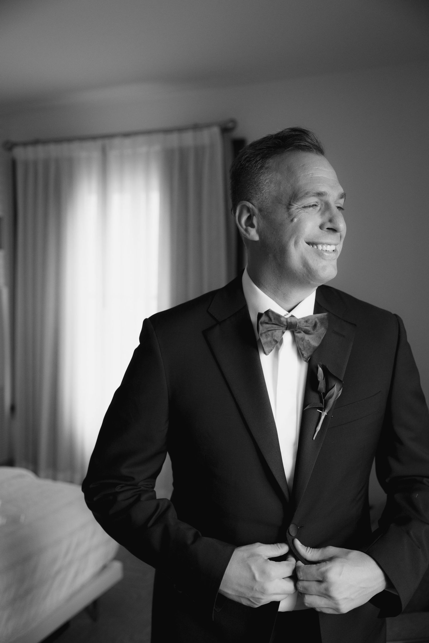 Smiling groom in black tuxedo before the ceremony at Le Méridien Tampa, Florida, captured by Grand Photo by Karyna Oliinyk
