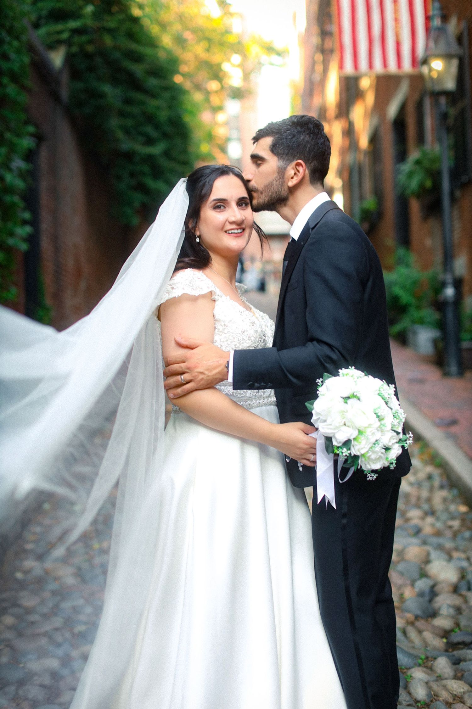 Groom kissing bride on cheek on historic Acorn Street in Boston, captured by Grand Photo by Karyna Oliinyk