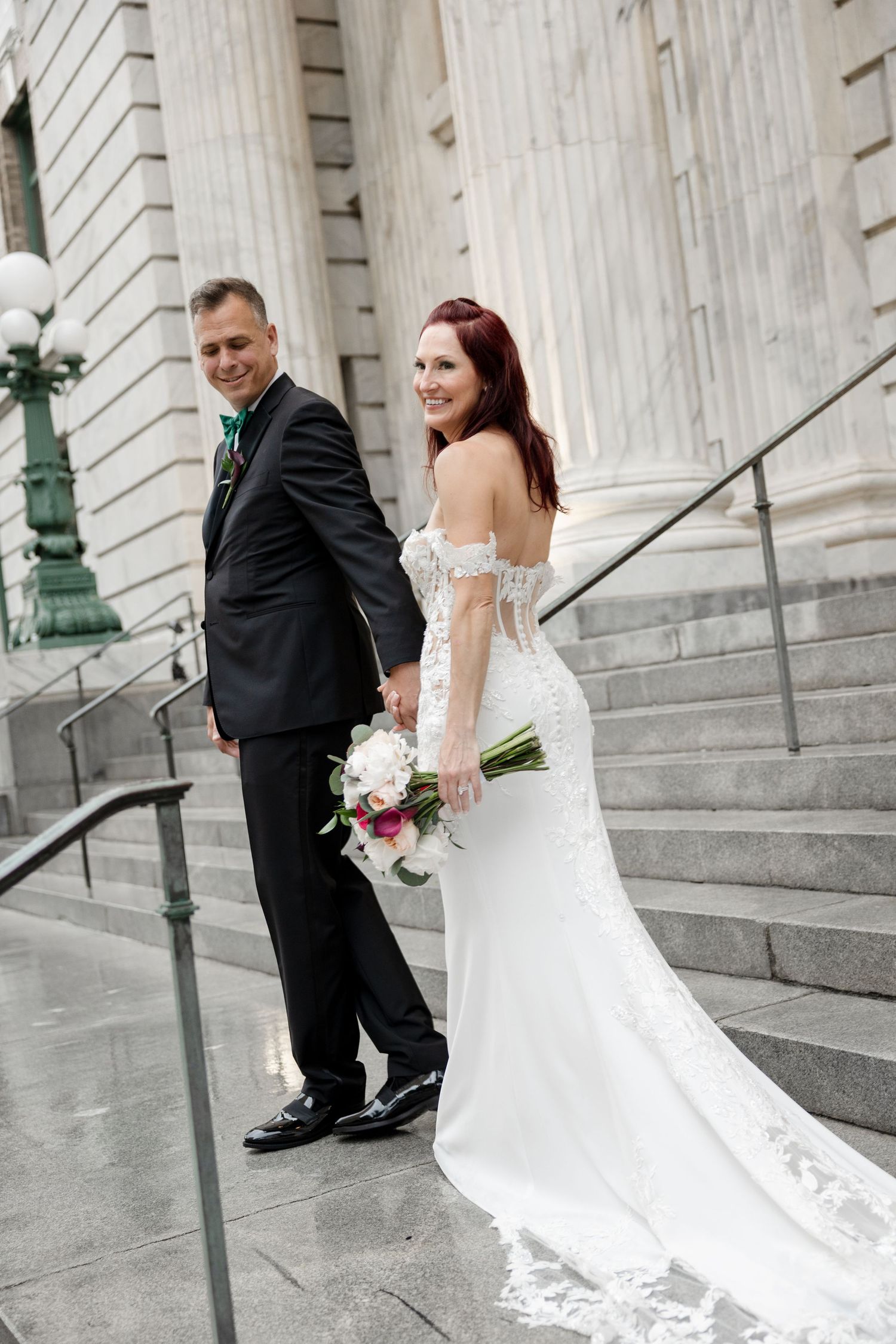 Bride and groom walking up stone steps at Le Méridien Tampa, Florida, captured by Grand Photo by Karyna Oliinyk
