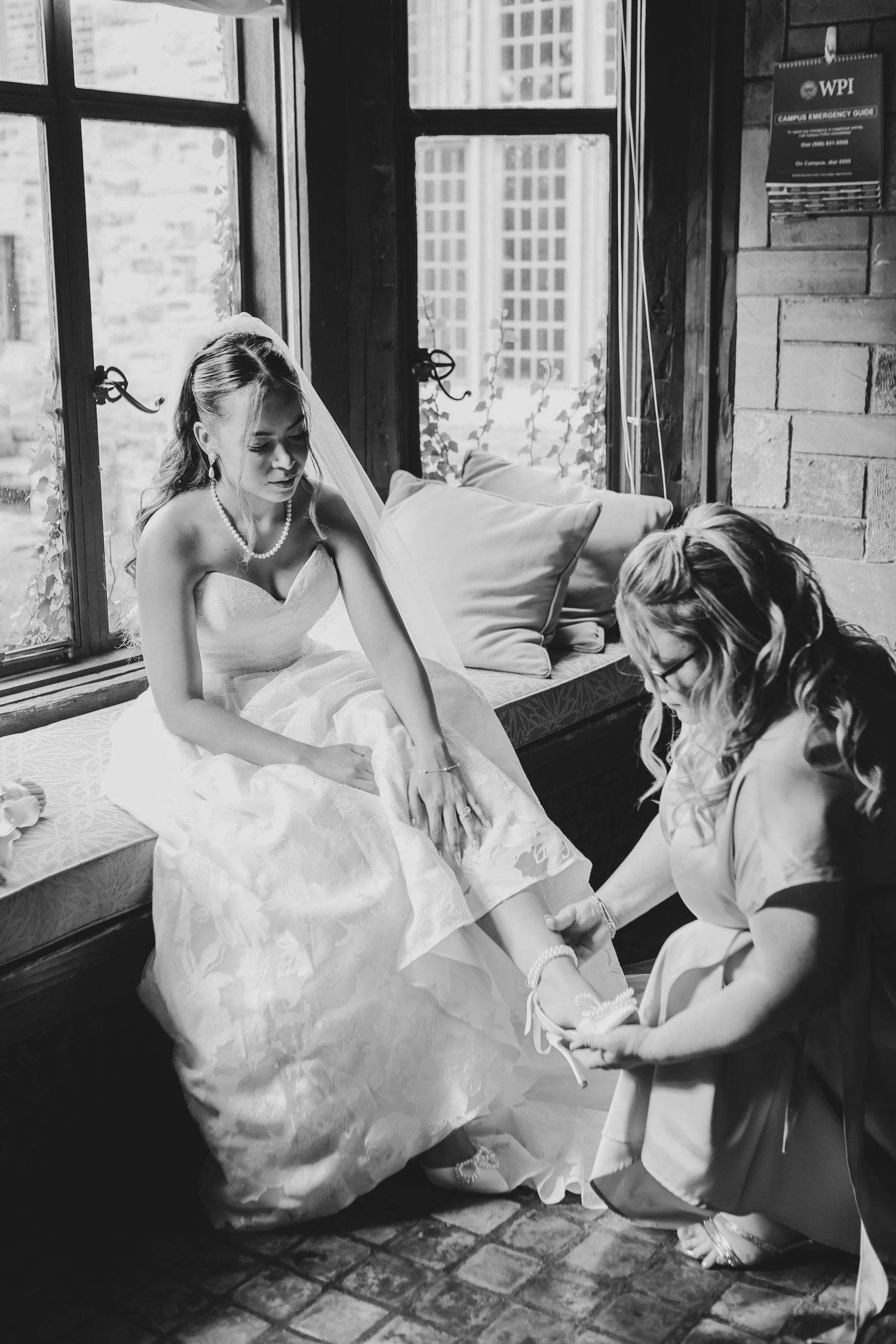 Bridesmaid helps bride with wedding shoe at Powel Crosley Estate in Sarasota, Florida, captured by Grand Photo by Karyna Oliinyk