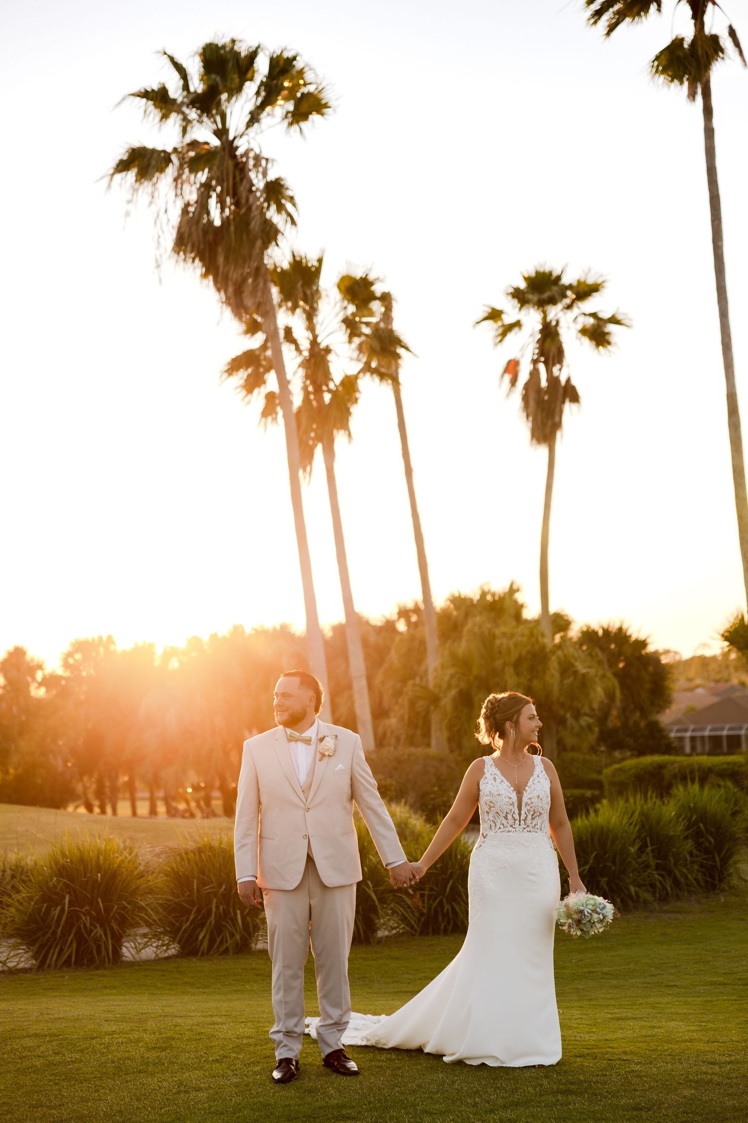 Wedding couple holding hands on golf course at sunset with palm trees, Heron Creek Golf & Country Club FL, wedding photographer Grand Photo