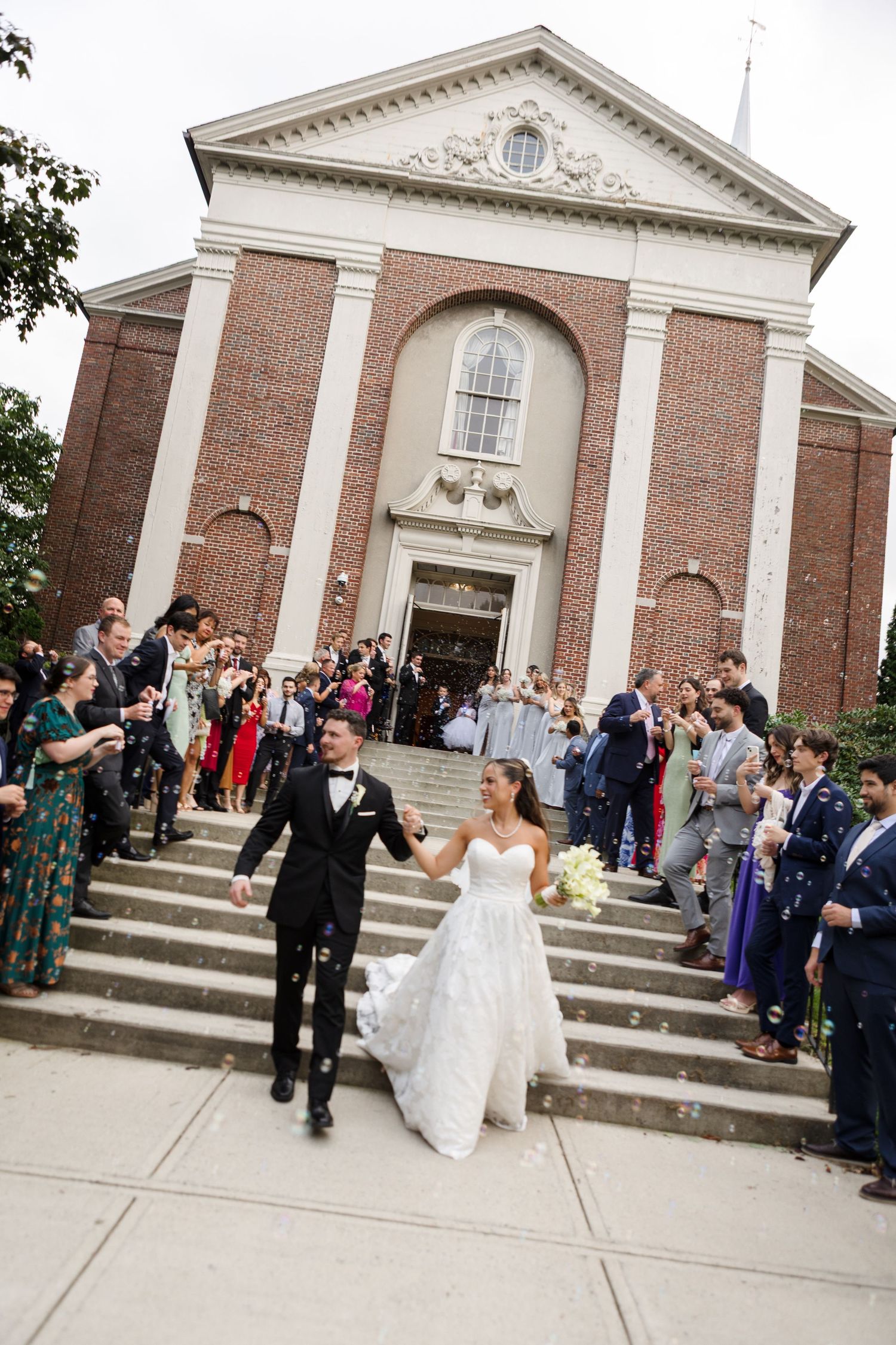 Bride and groom grand exit after ceremony through bubbles in Boston, captured by Grand Photo by Karyna Oliinyk