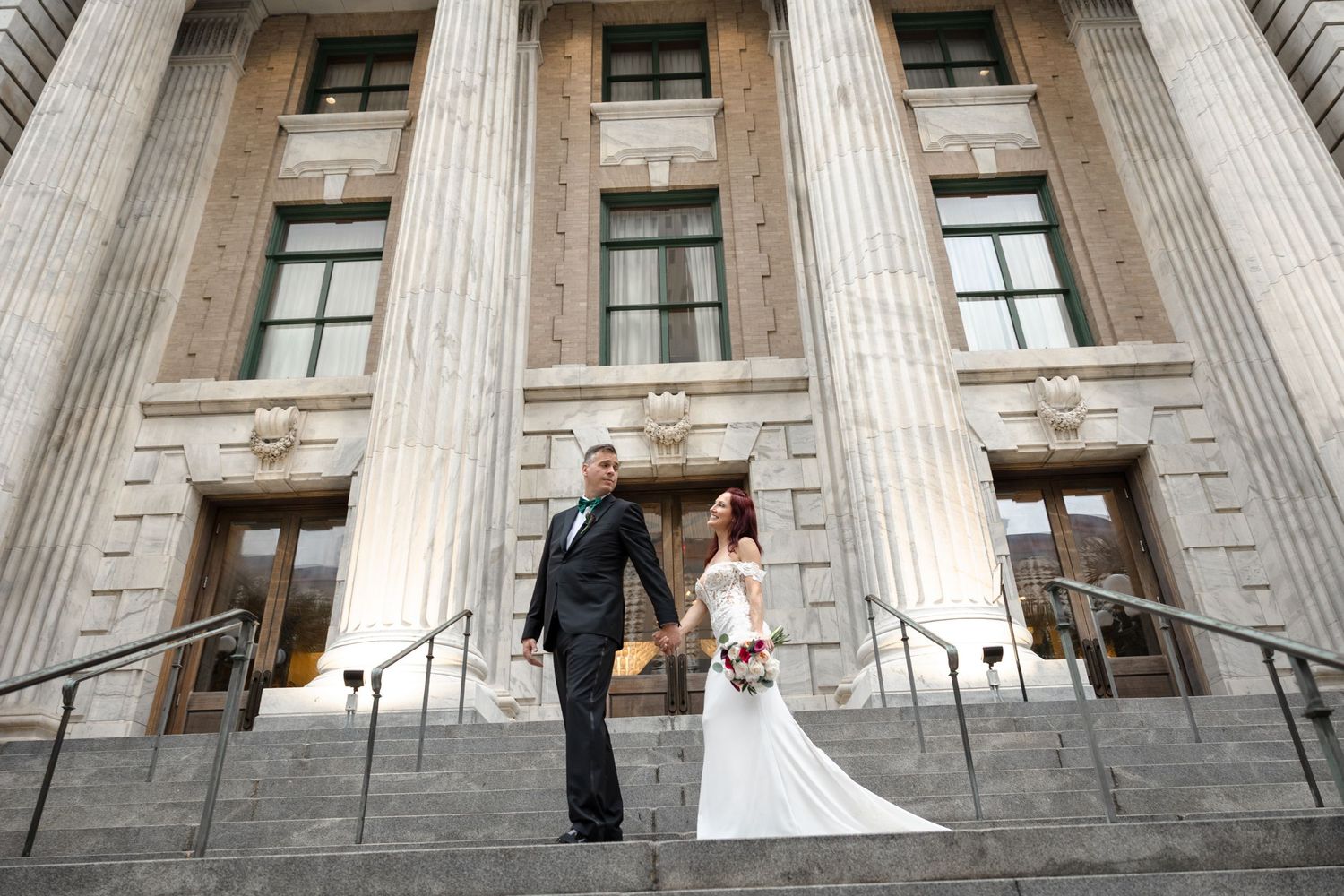 Bride and groom walking on grand staircase at Le Méridien Tampa, Florida, captured by Grand Photo by Karyna Oliinyk