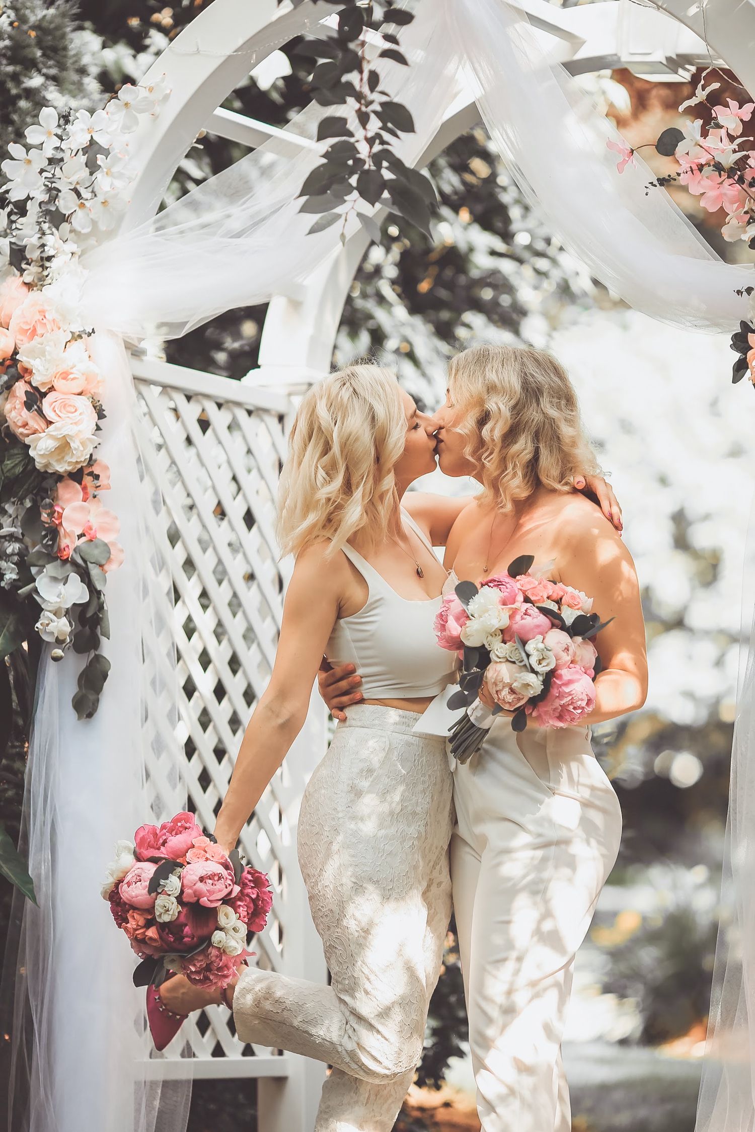 Two brides share first kiss at outdoor wedding at Powel Crosley Estate in Sarasota, Florida, captured by Grand Photo by Karyna Oliinyk