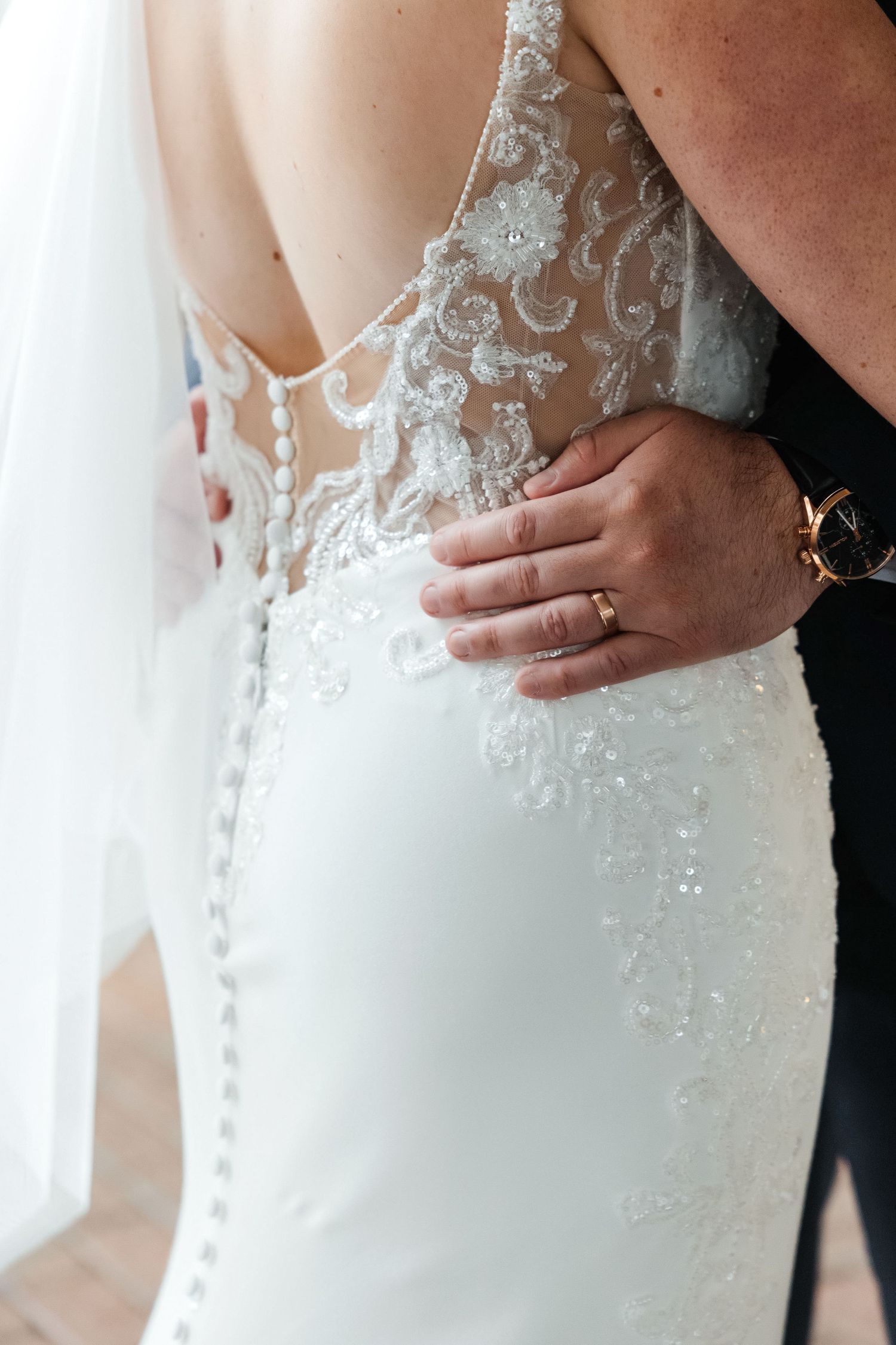 Close-up of groom placing hand on bride's waist showing wedding rings - at Oxford Exchange — Tampa Bay FL wedding photographer Grand Photo
