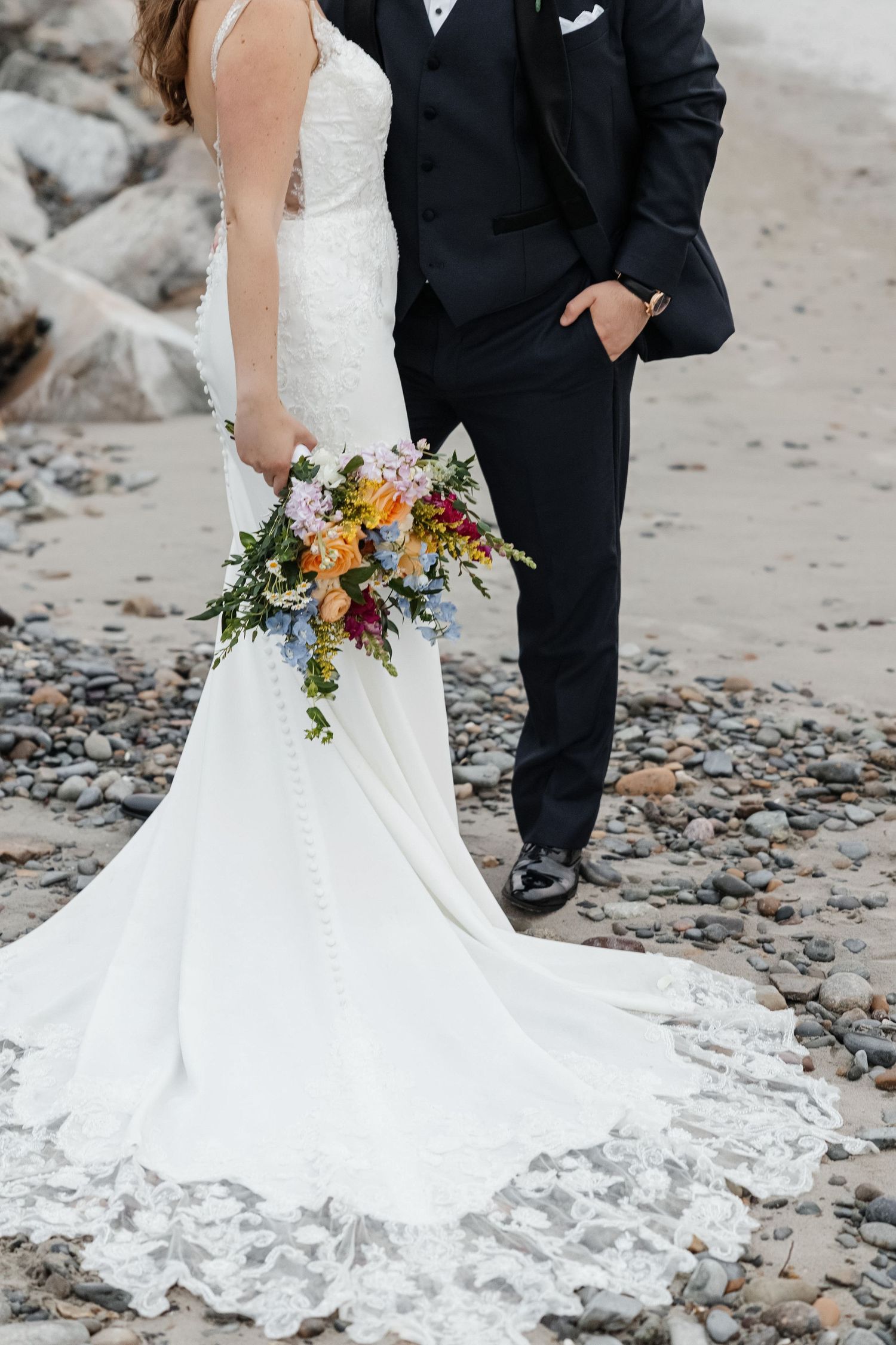 Bride in lace gown holding vibrant wildflower bouquet at The Birchwood in St. Petersburg, Florida, captured by Grand Photo by Karyna Oliinyk
