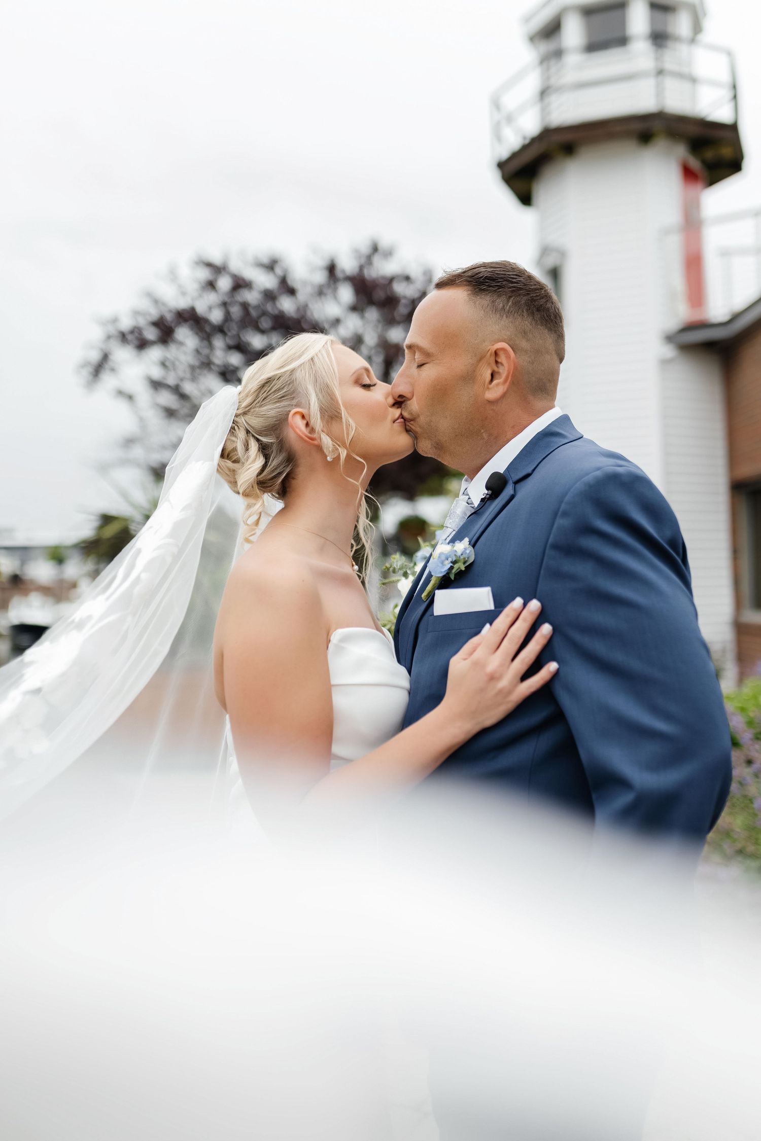 A bride and groom kiss in front of Key Largo Lighthouse Key Largo, FL— wedding photographer Grand Photo, Karyna Oliinyk