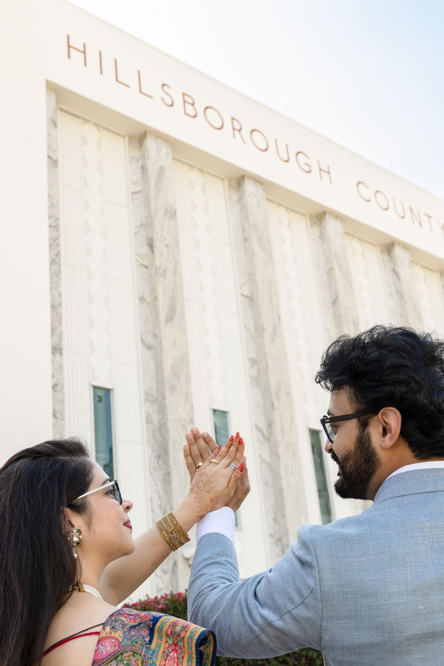 Indian couple holding hands outside of Hillsborough County Courthouse Tampa, Florida, captured by Grand Photo by Karyna Oliinyk