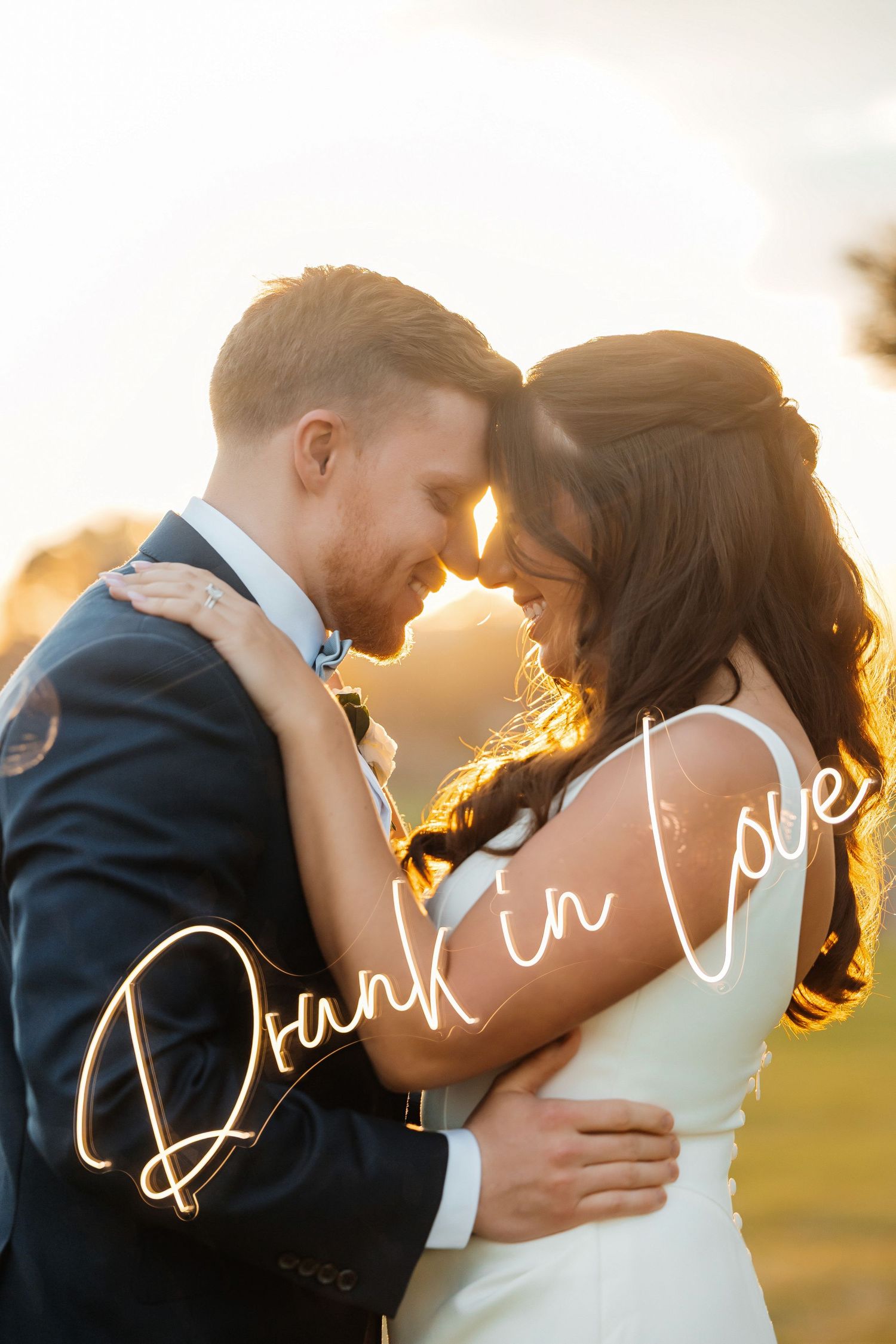 Sunset photos of bride and groom with neon sign at Oceanview of Nahant in Nahant, Massachusetts, captured by Grand Photo by Karyna Oliinyk