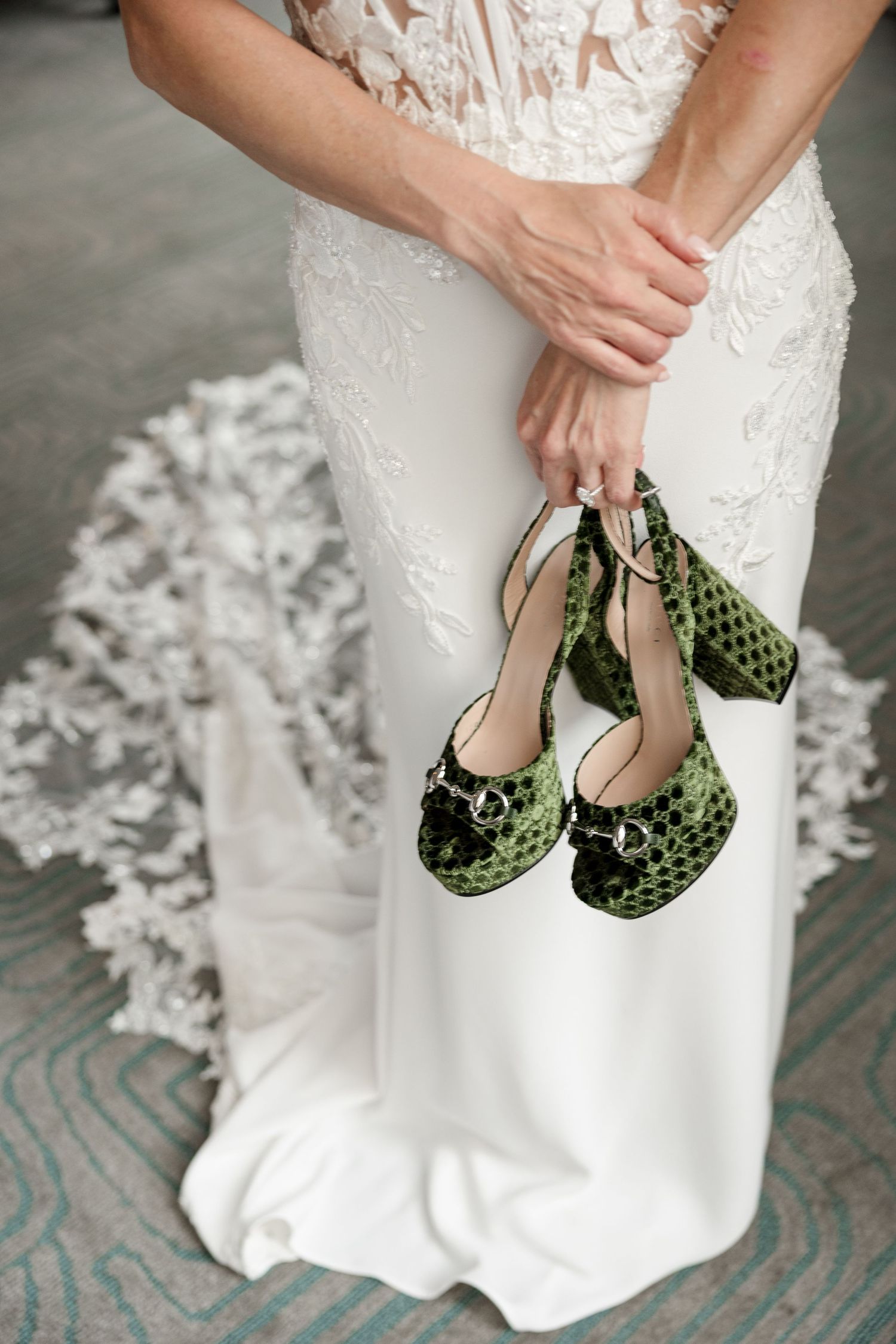 Bride in white lace gown holding green velvet  Gucci heels at Le Méridien Tampa, Florida, captured by Grand Photo by Karyna Oliinyk