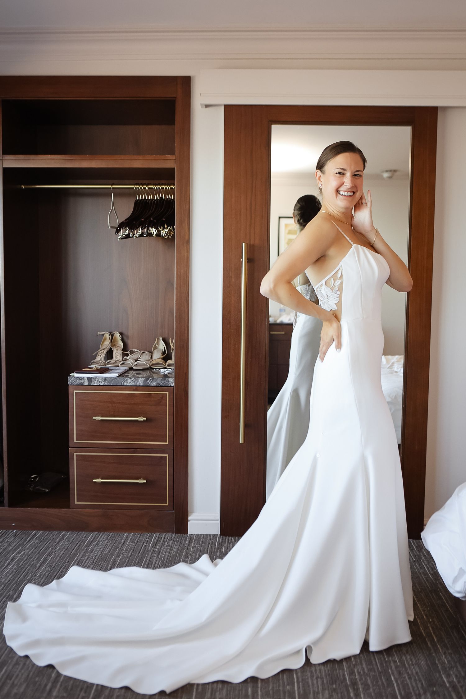 Bride getting ready in satin wedding gown before ceremony at Boston Harbor Hotel in Boston, Massachusetts, captured by Grand Photo