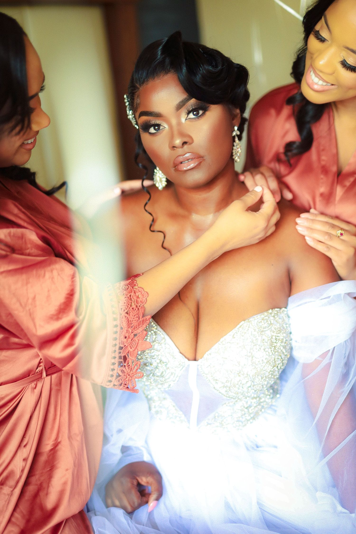 Bride in beaded gown being helped by bridesmaids during getting ready at The Tampa Club in Tampa, Florida, captured by Grand Photo