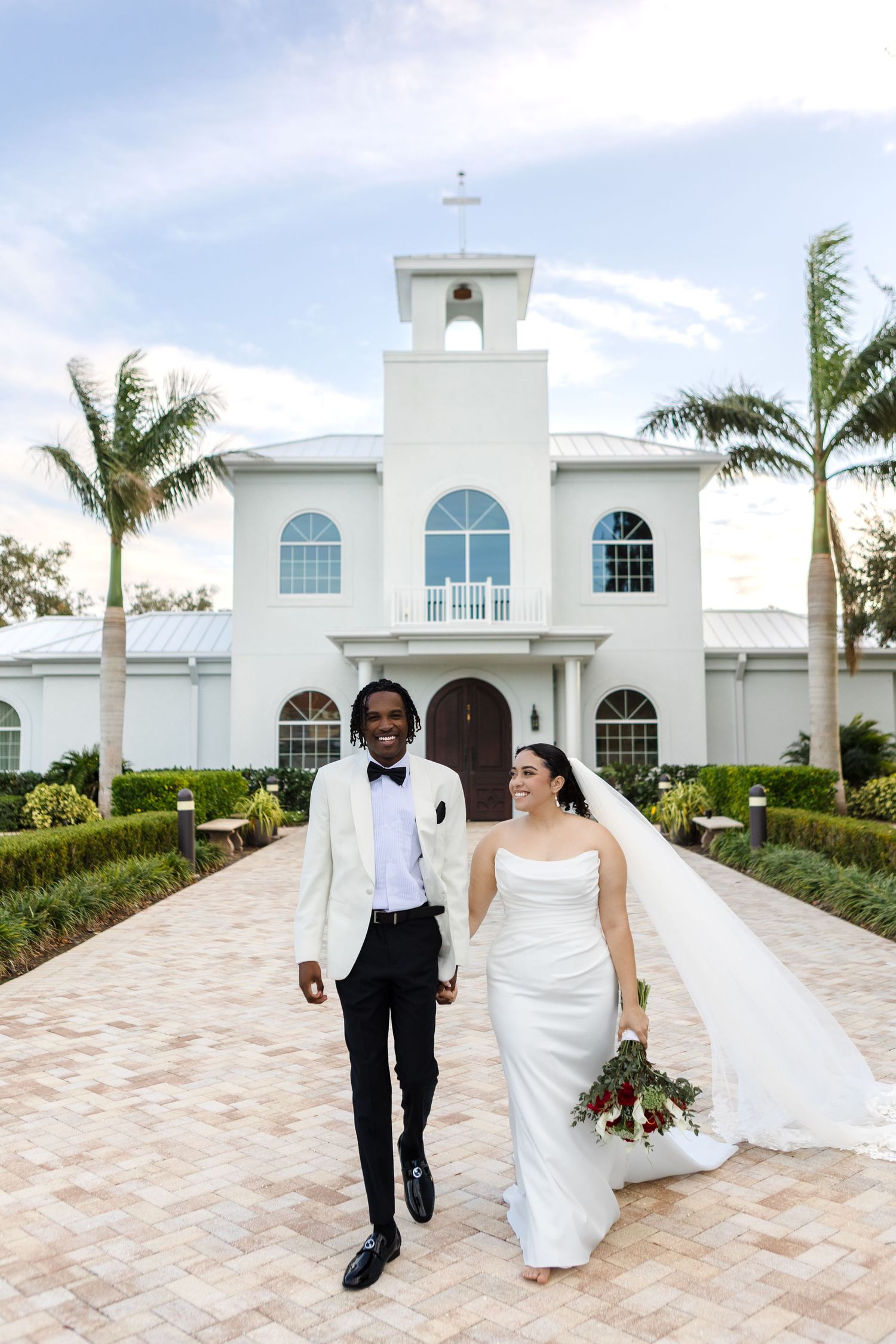 Bride and groom walking front of Harborside Chapel in Safety Harbor, Florida — wedding photographer Grand Photo, Karyna Oliinyk