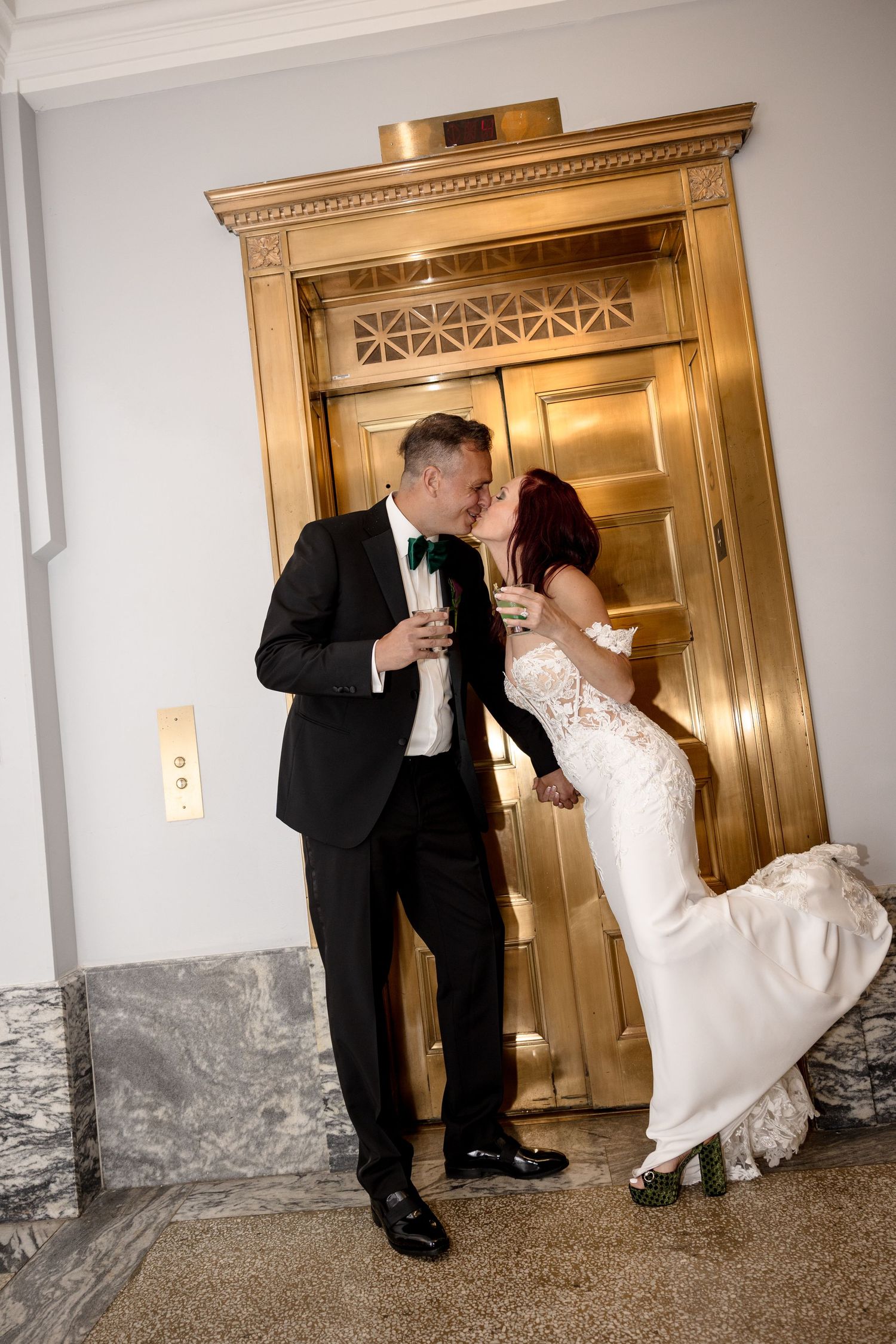 Bride and groom kissing in front of gold elevator at Le Méridien Tampa, Florida, captured by Grand Photo by Karyna Oliinyk